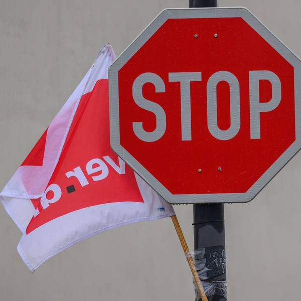Eine Fahne der Gewerkschaft Verdi weht neben einem Stoppschild.
