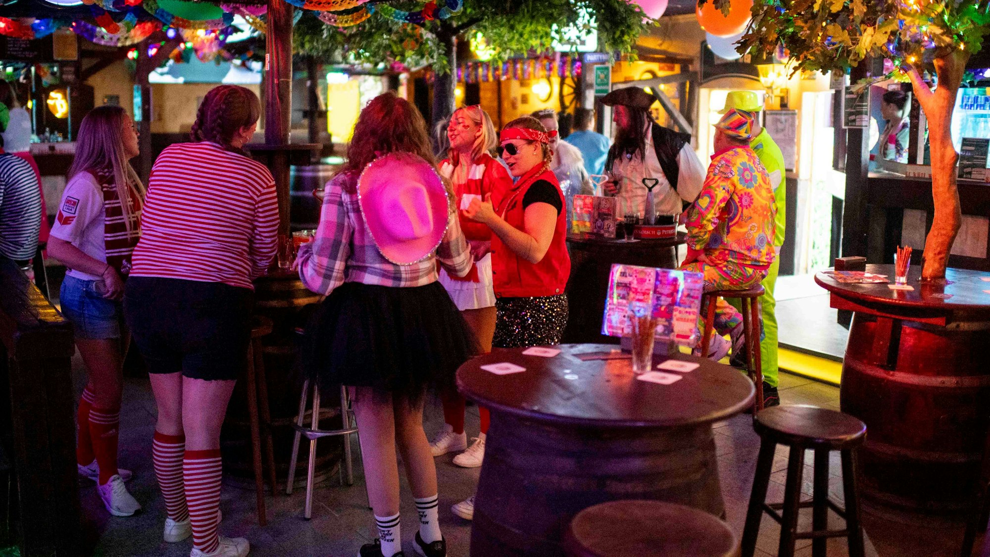 Das Bild zeigt die Disco in Zülpich. Einige Jecke stehen an Tischen und trinken ein Kölsch.