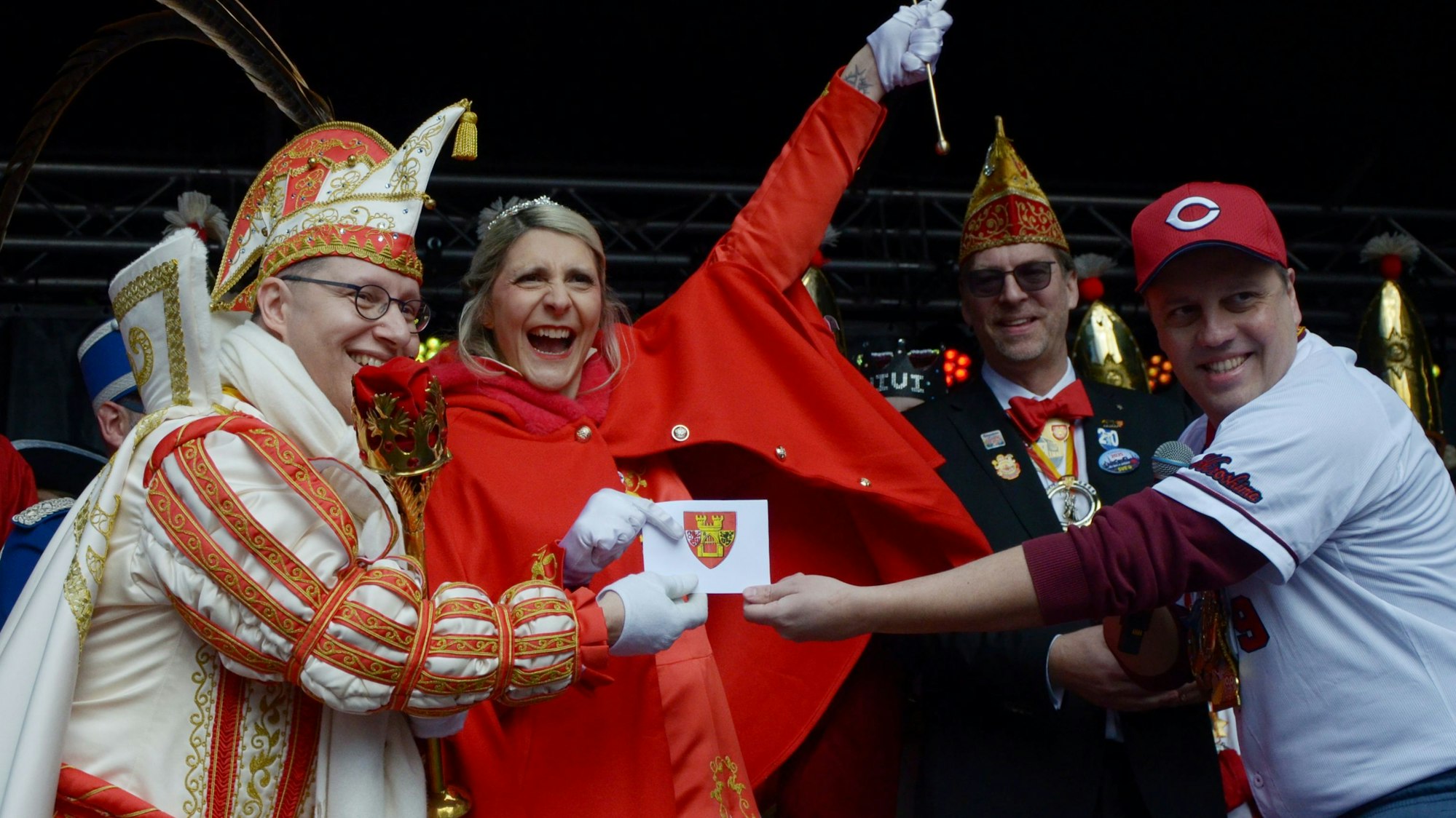Das Euskirchener Prinzenpaar jubelt, als es von Bürgermeister Sacha Reichelt in einem Umschlag mit dem Stadtwappen den Schlüssel erhält.