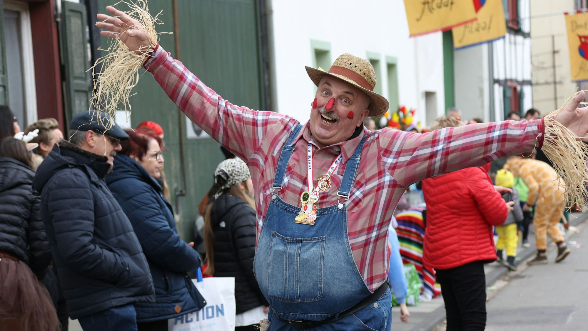 Als Vogelscheuche verkleidet und mit ausgebreiteten Armen geht ein Zugteilnehmer durch Dom-Esch.