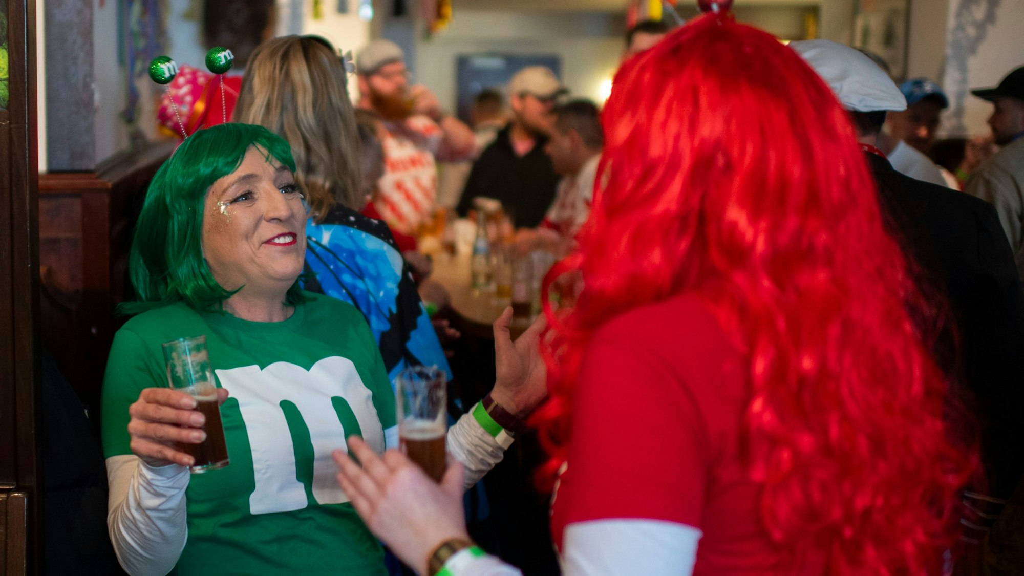 Zwei weibliche Jecken, die am M&M verkleidet sind, tanzen in der Kneipe.