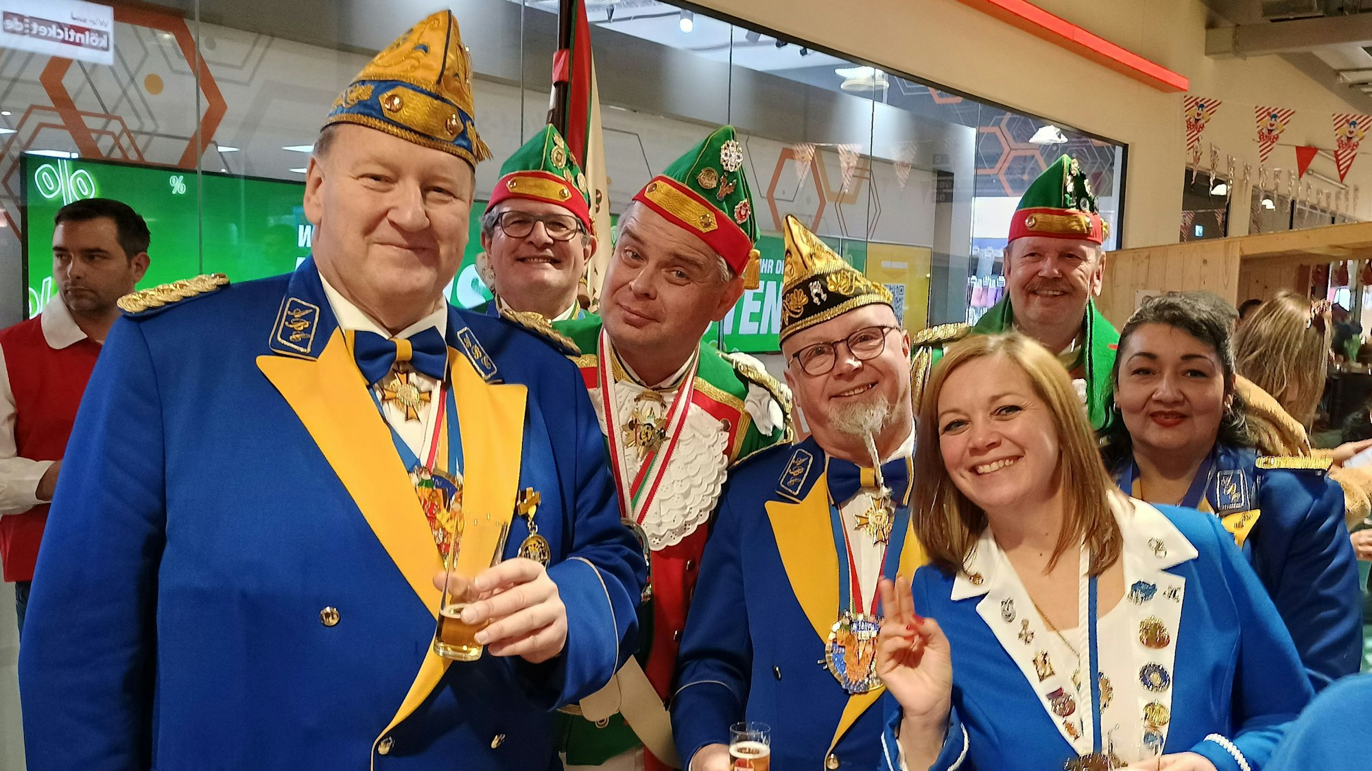 Die verschiedenen Karnevalisten tragen ihre Uniformen und lächeln in die Kamera.