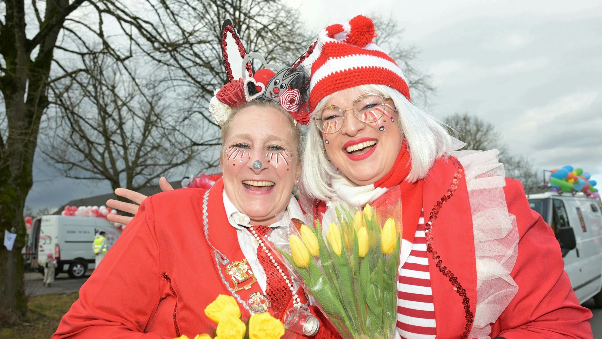 Zwei Frauen im rot-weißen Karnevalskostüm lachen in die Kamera.