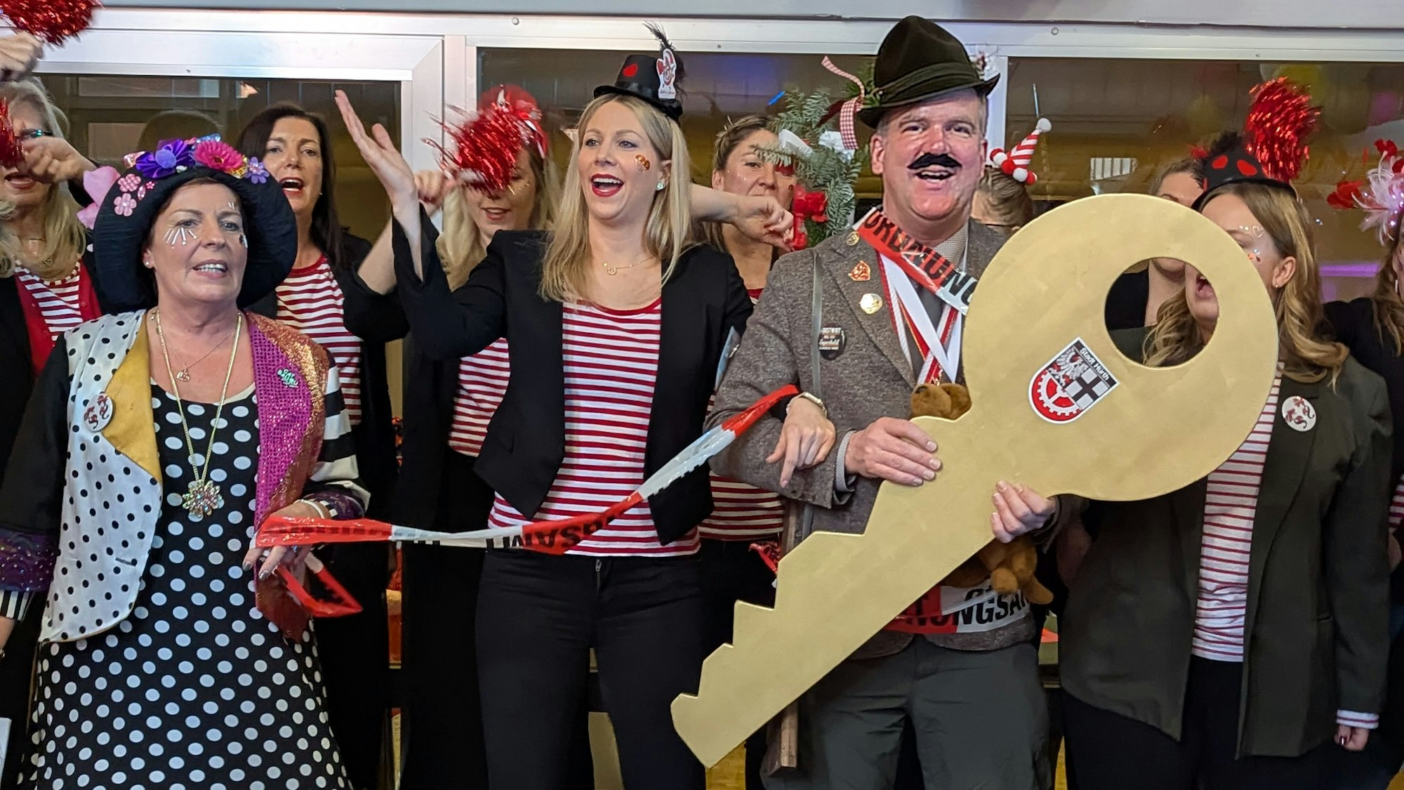 Die Foto zeigt den Bürgermeister mit überdimensionalem Schlüssel neben den jecken Frauen aus der Verwaltung.
