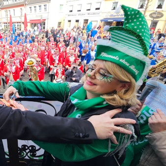 Zu sehen ist, wie eine kostümierte Frau Bedburgs Bürgermeister Sascha Solbach die Krawatte abschneidet.