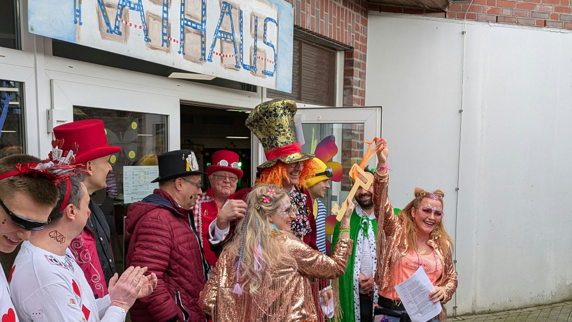 Karnevalistinnen in Burscheid halten triumphierend einen Pappschlüssel in die Höhe.