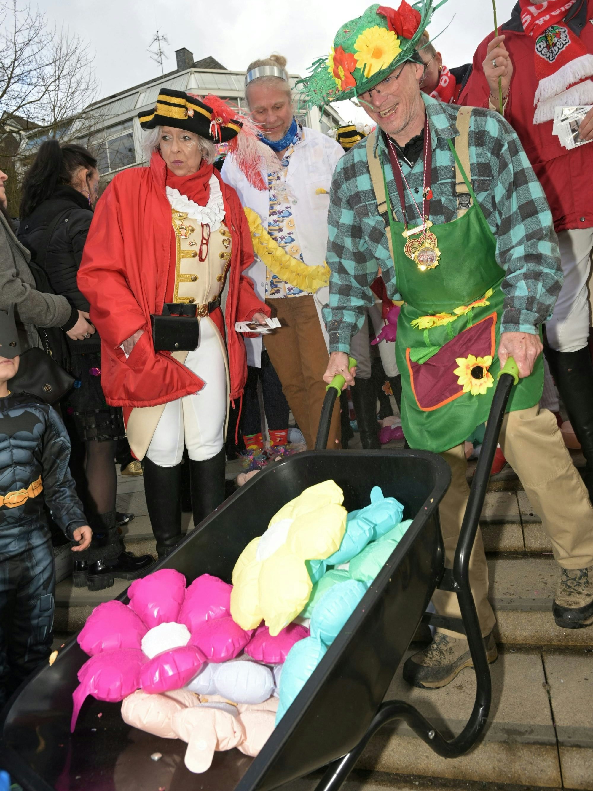 Bürgermeister Frank Stein schiebt eine Schubkarre mit Plastikblumen die Schlosstreppe hinunter.