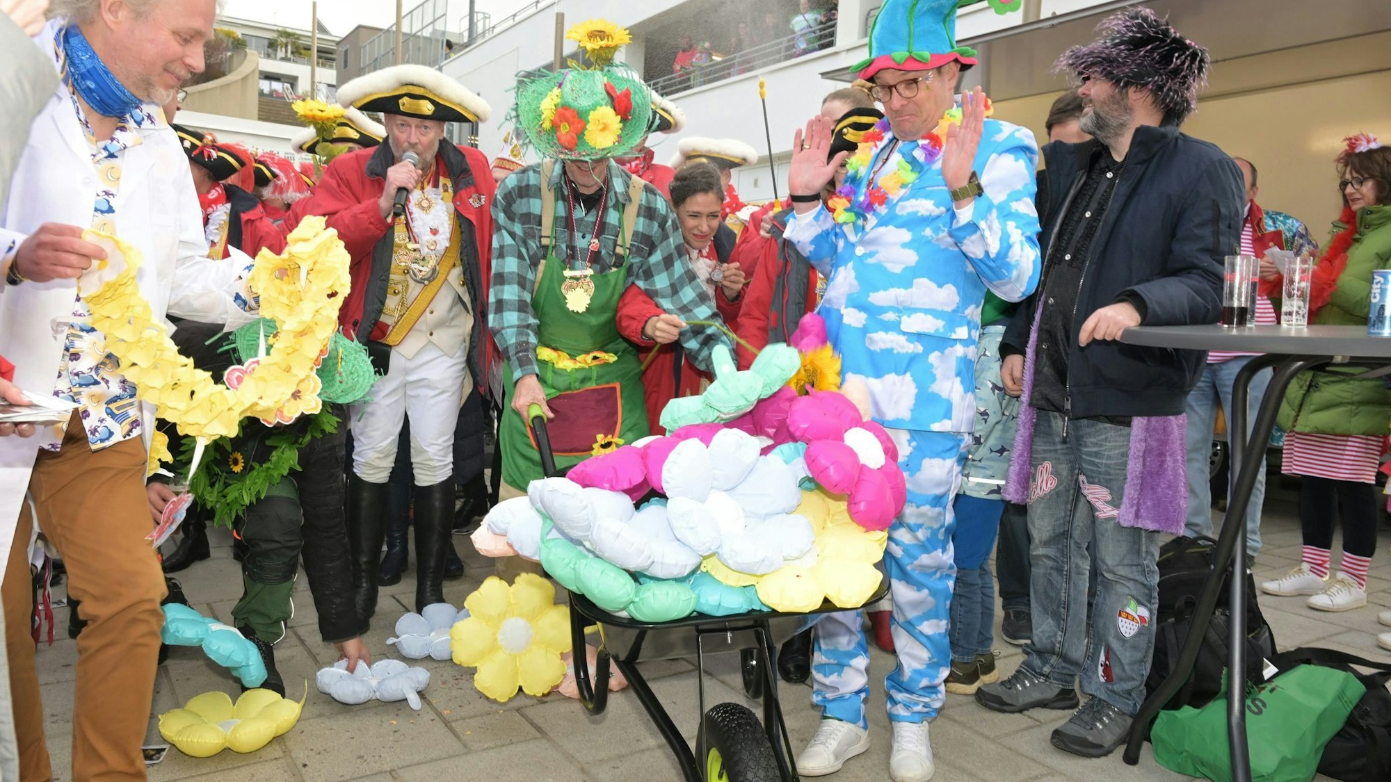 Neben Bürgermeister Frnak Stein mit Schubkarre steht der Beigeordnete Thore Eggert und hebt die Hände hoch.