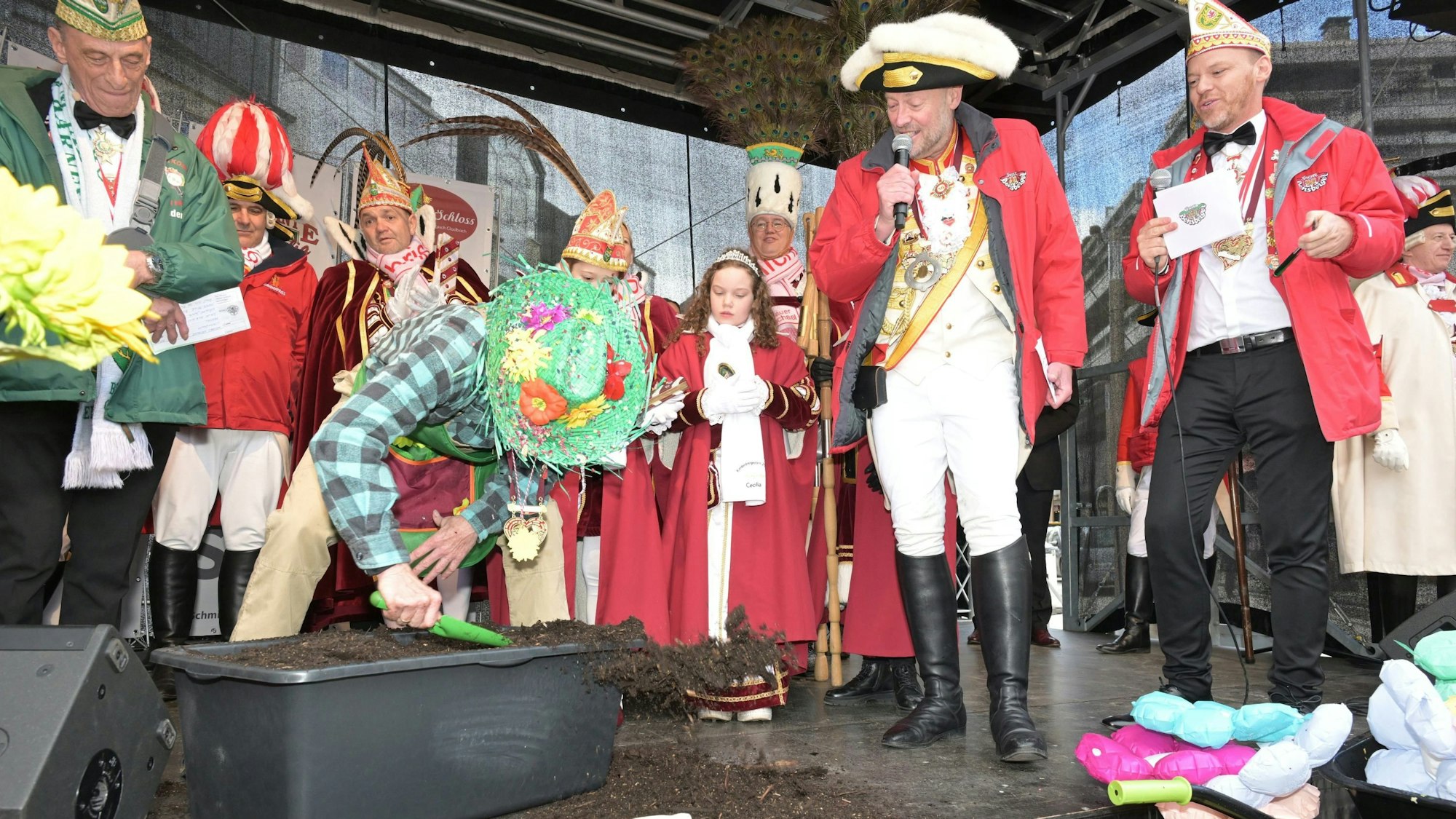 Bürgermeister Frank Stein gräbt mit einer Schaufel in einem Bottich mit Erde.