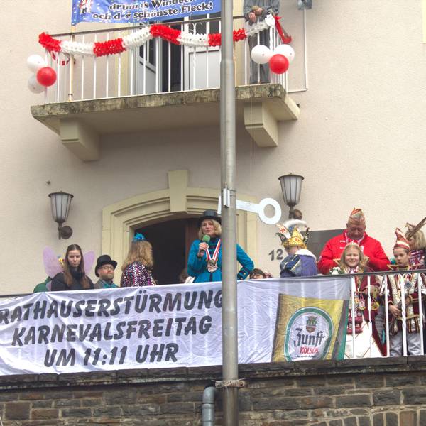 Verkleidete Menschen und Bürgermeisterin Alexandra Gauß stehen auf dem Balkon des Rathauses in Windeck-Rosbach.