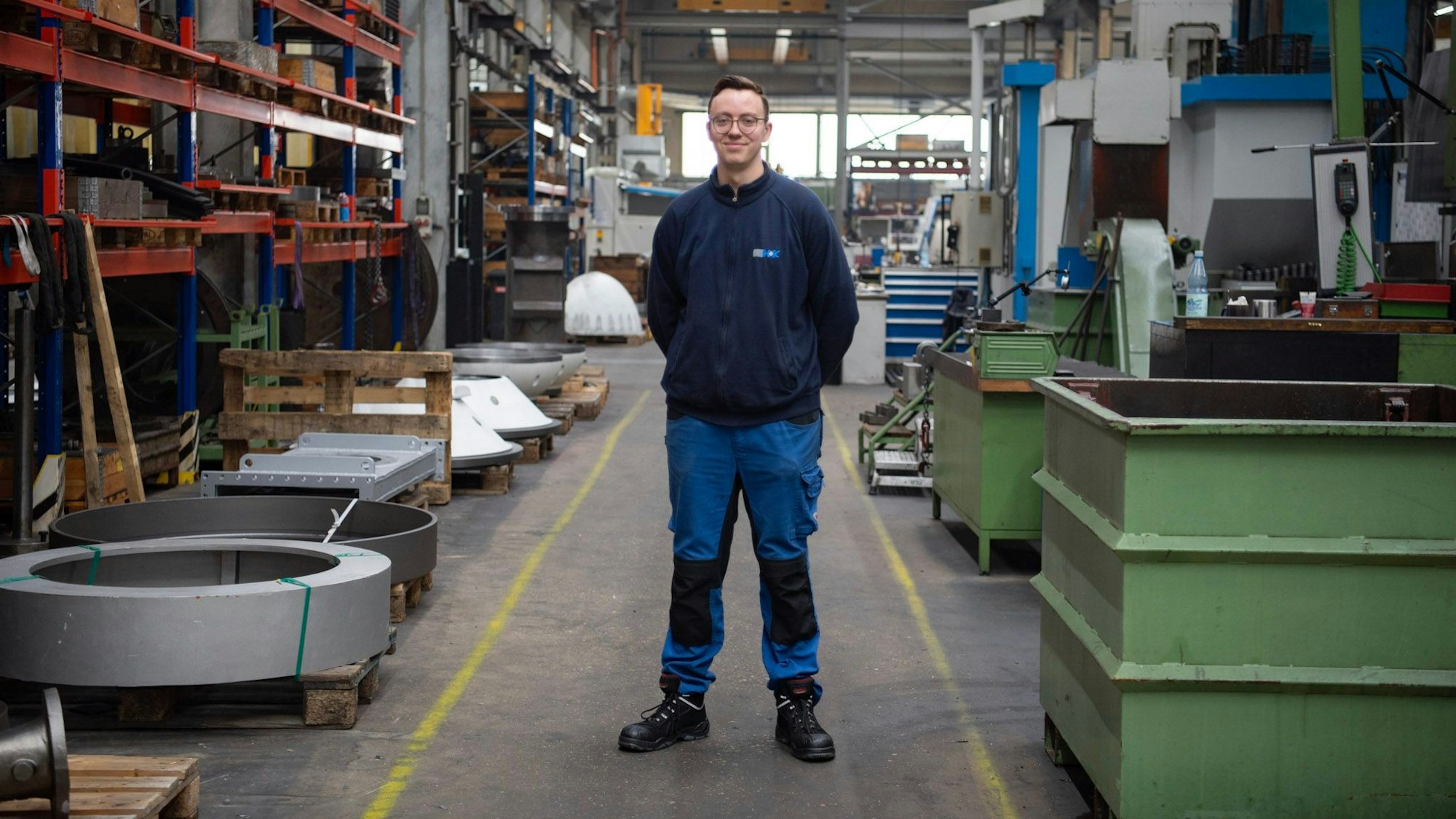 Zerspahnungsmeister Leon Fischernich steht in der Werkhalle von Hecker und Krosch.