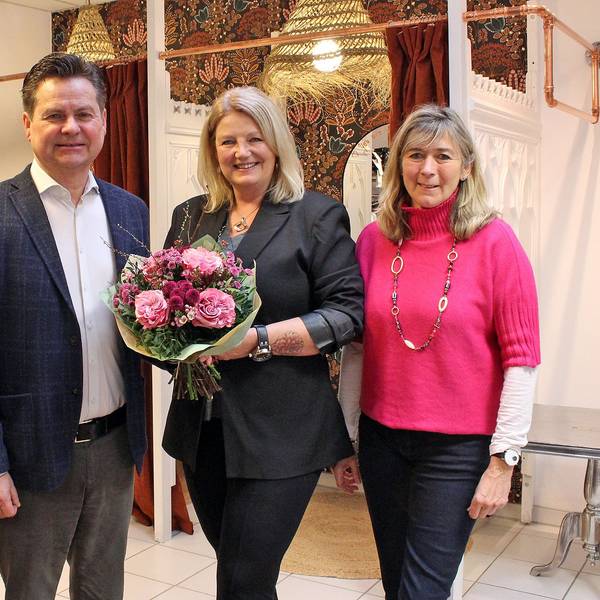Ein Herr mit Blumenstrauß und drei Damen.