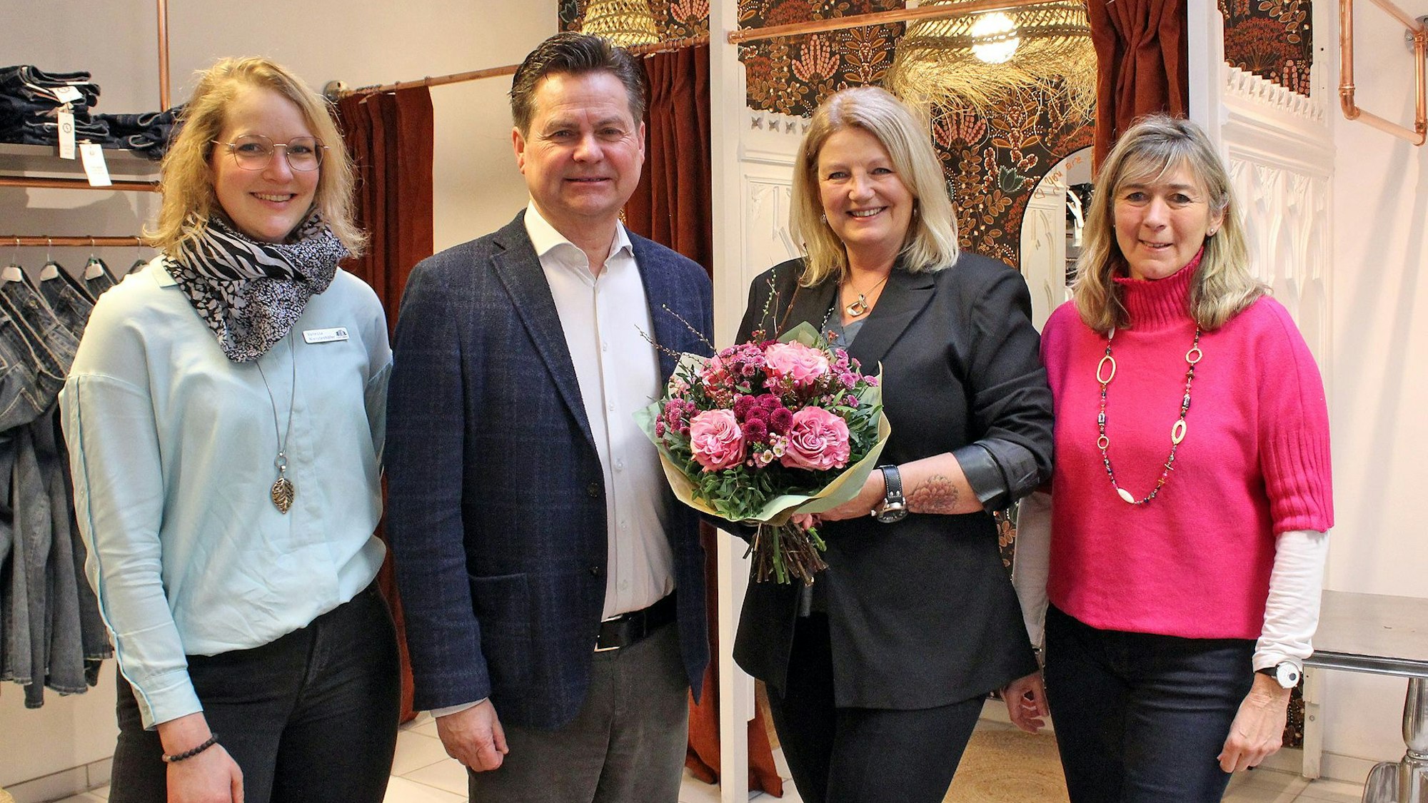 Ein Herr mit Blumenstrauß und drei Damen.