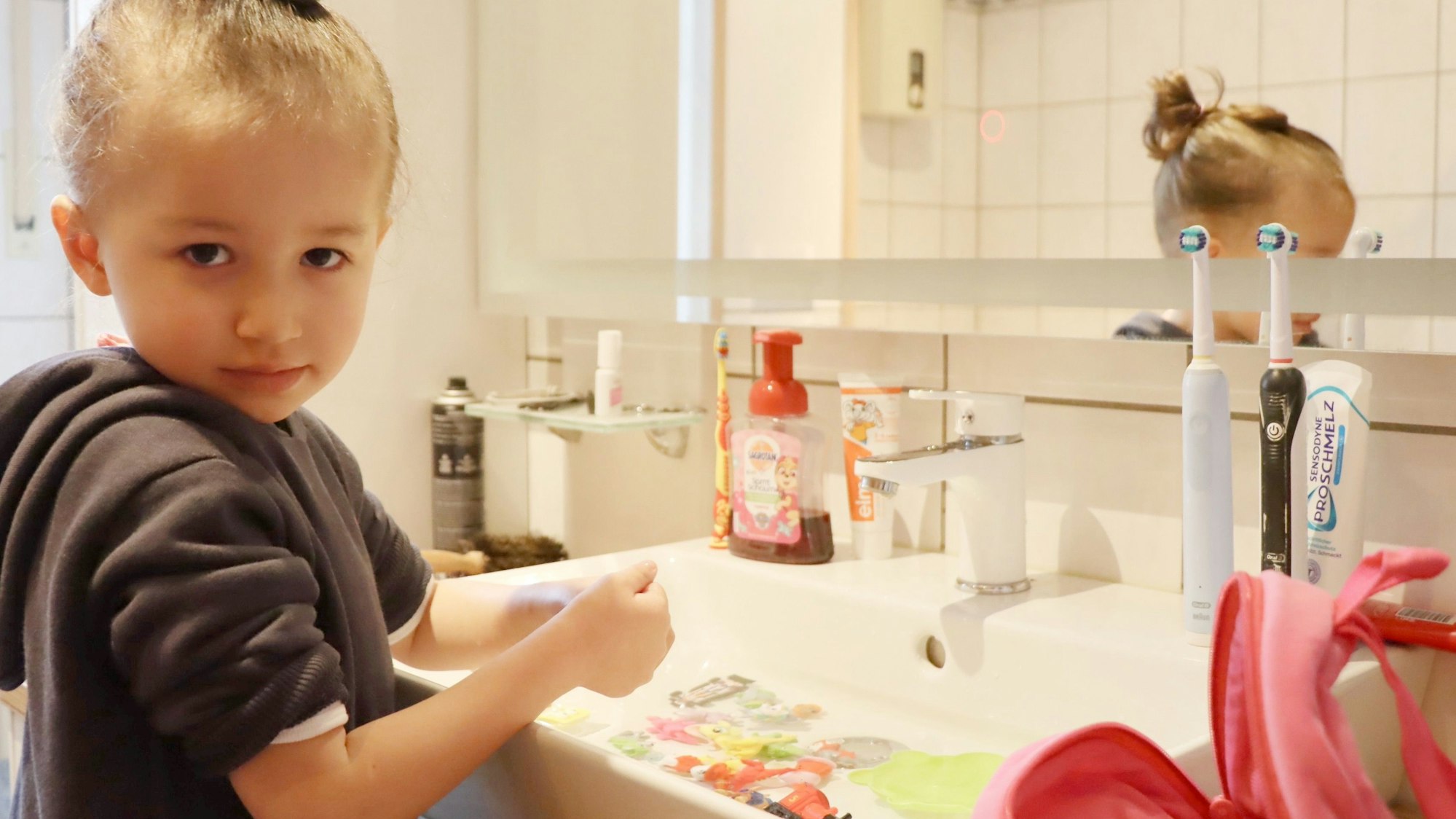 Das Foto zeigt ein kleines Mädchen am Waschbecken.