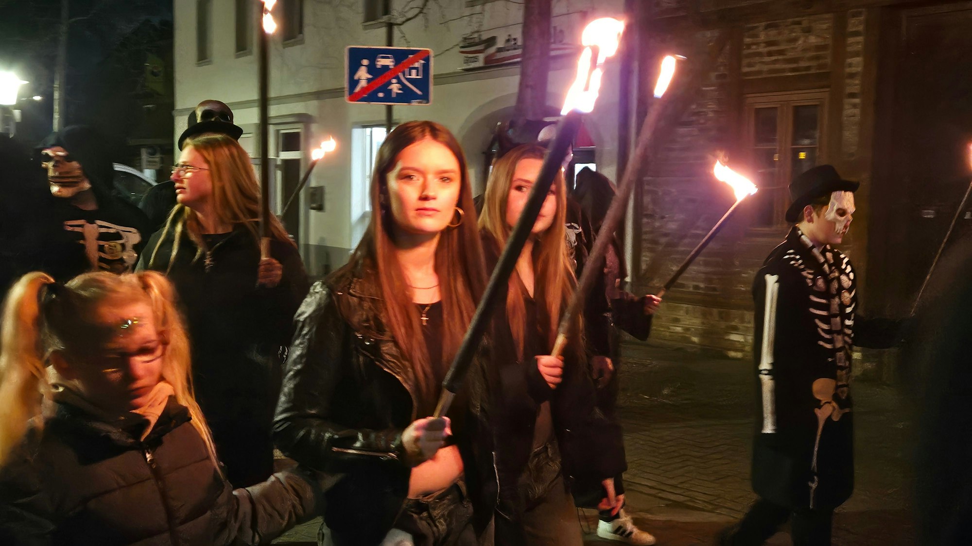 Zu sehen sind die Teilnehmer an einem Geisterzug mit Fackeln in der Hand.