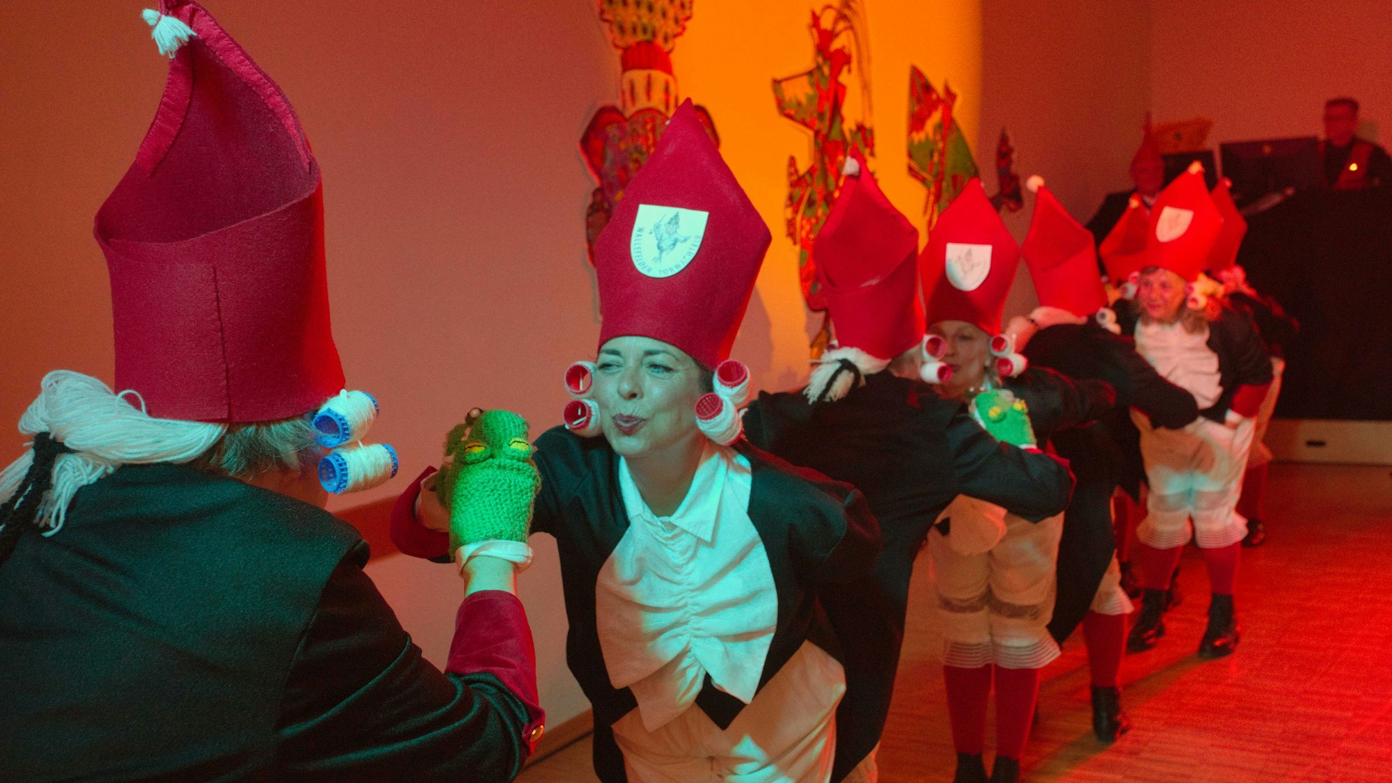 Eine Frauengruppe als Wallefelder Torwachteln verkleidet bei einem Auftritt auf einer Karnevalsbühne.