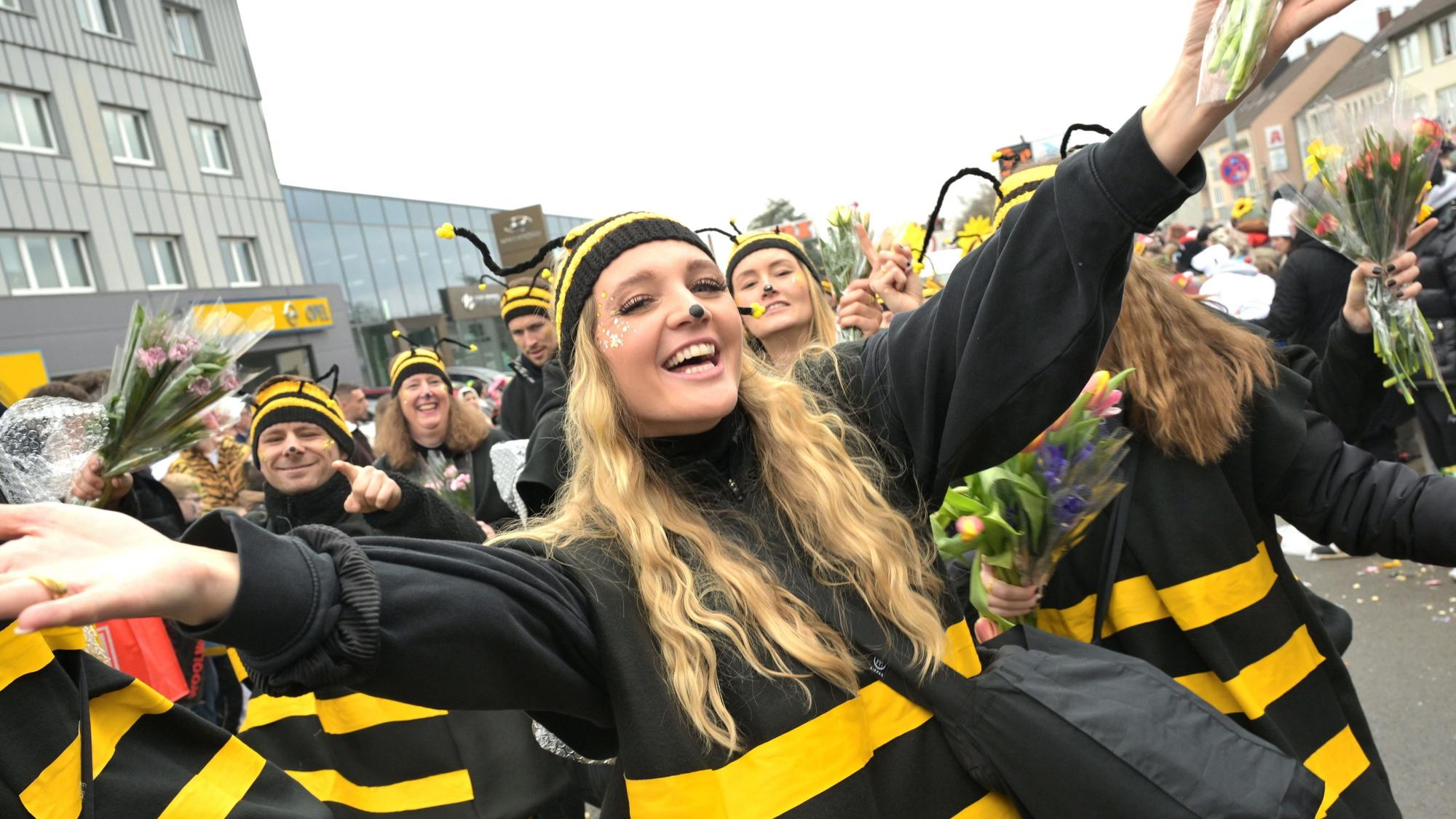 Als Bienen verkleidete Frauen laufen über die Straße.
