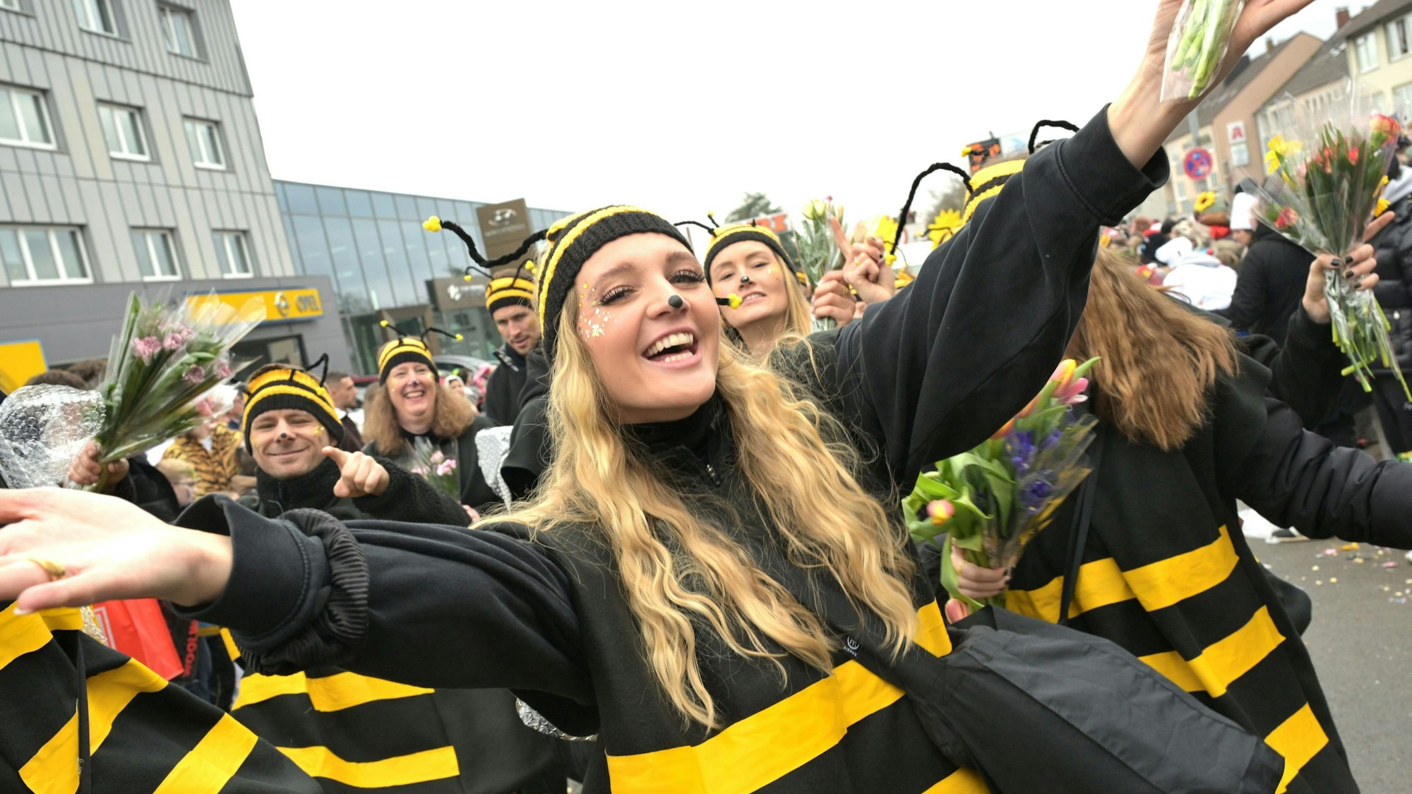 Als Bienen verkleidete Frauen laufen über die Straße.