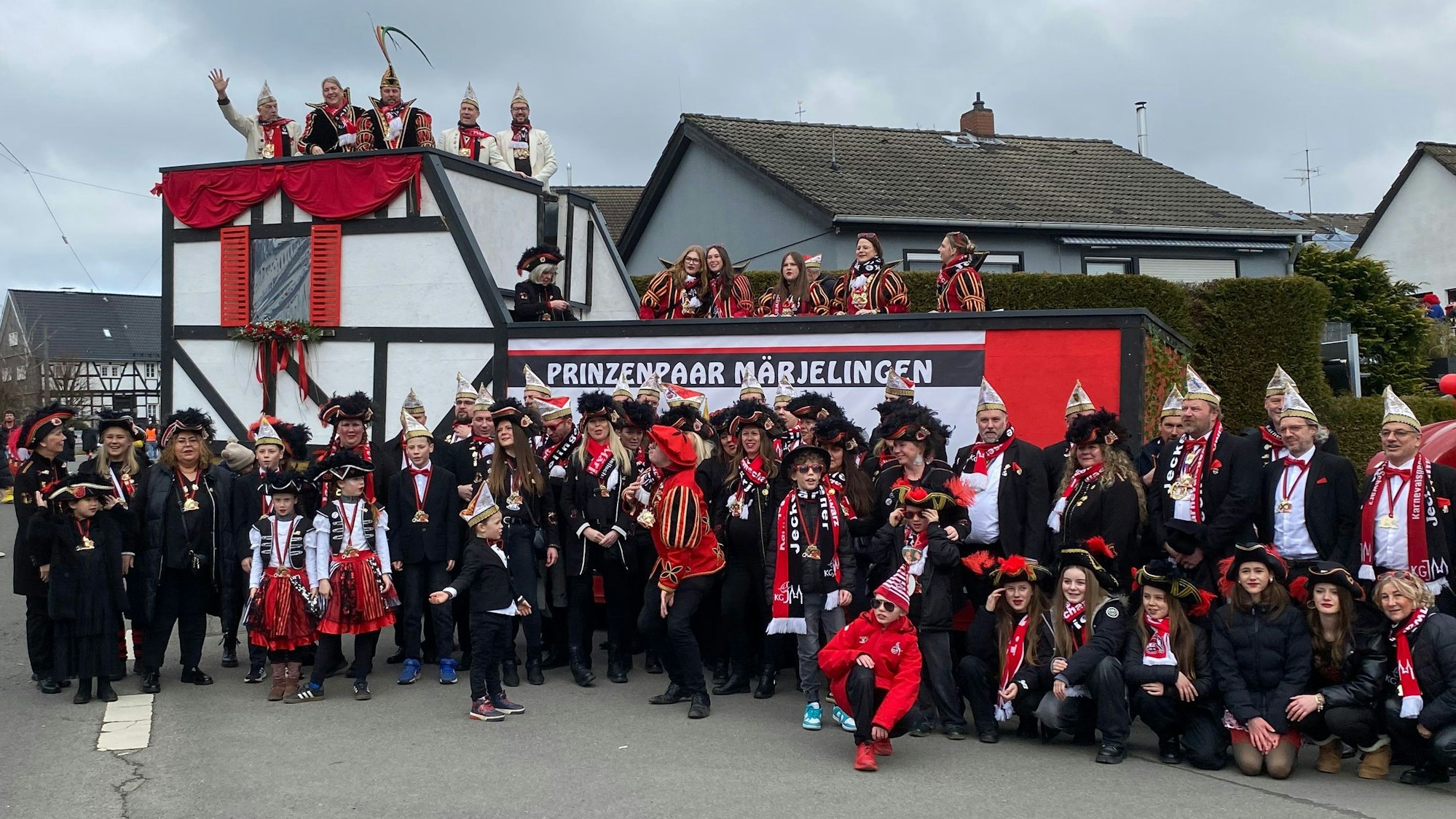 Leute stehen vor und auf einem Karnevalswagen mit der Aufschrift „Prinzenpaar Marialainden“.
