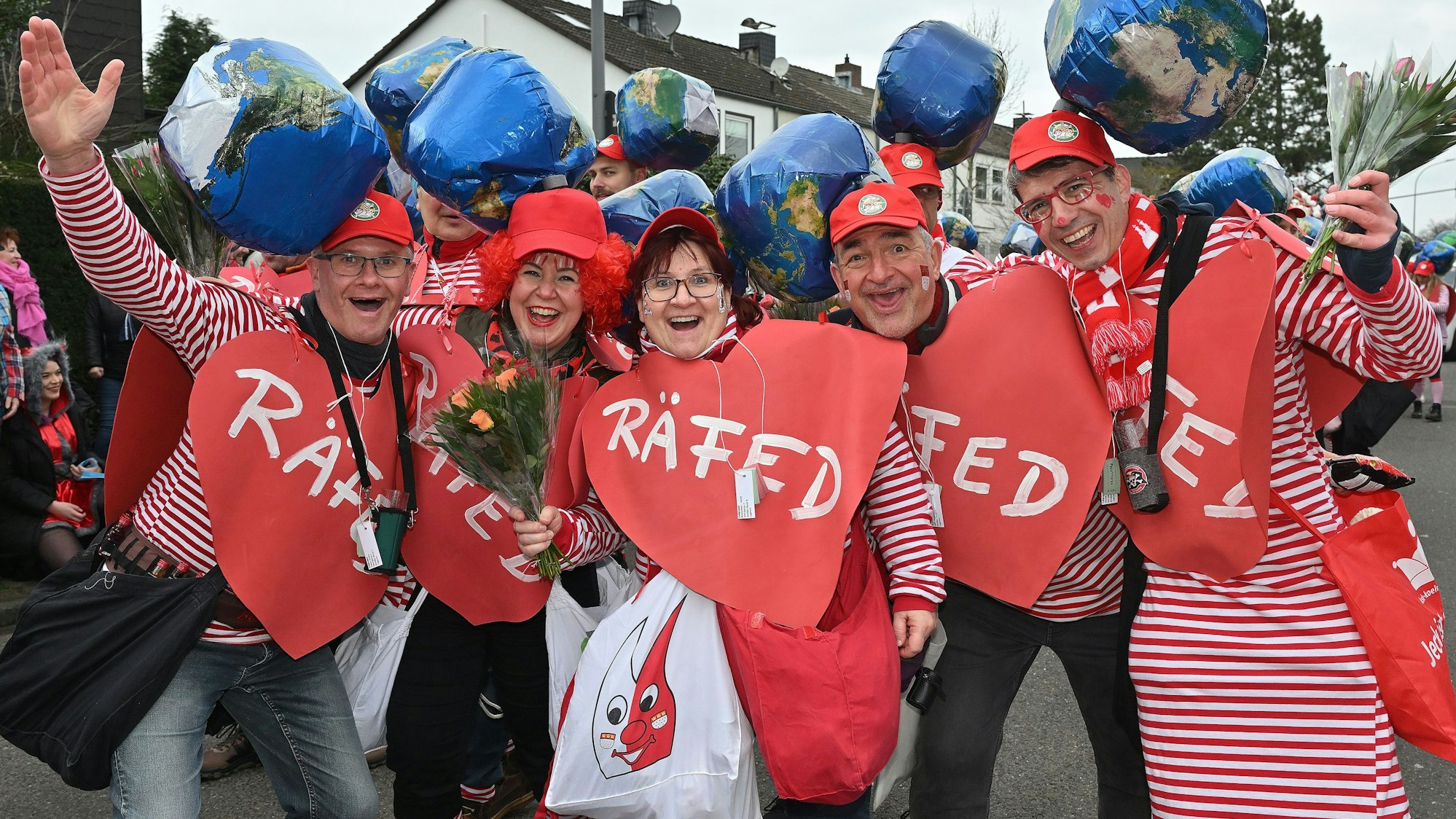 Jecken mit Herz stehen in einer Reihe.