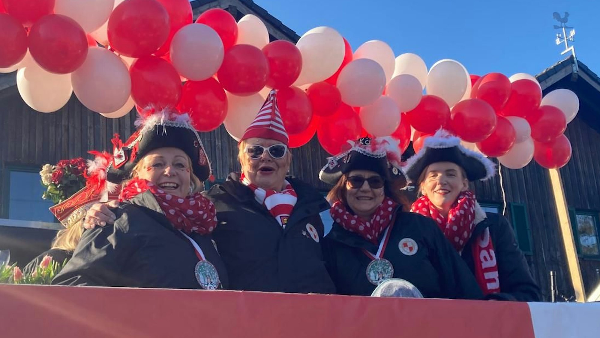 Vier Karnevalistinnen lachen bei gutem Wetter im die Kamera.