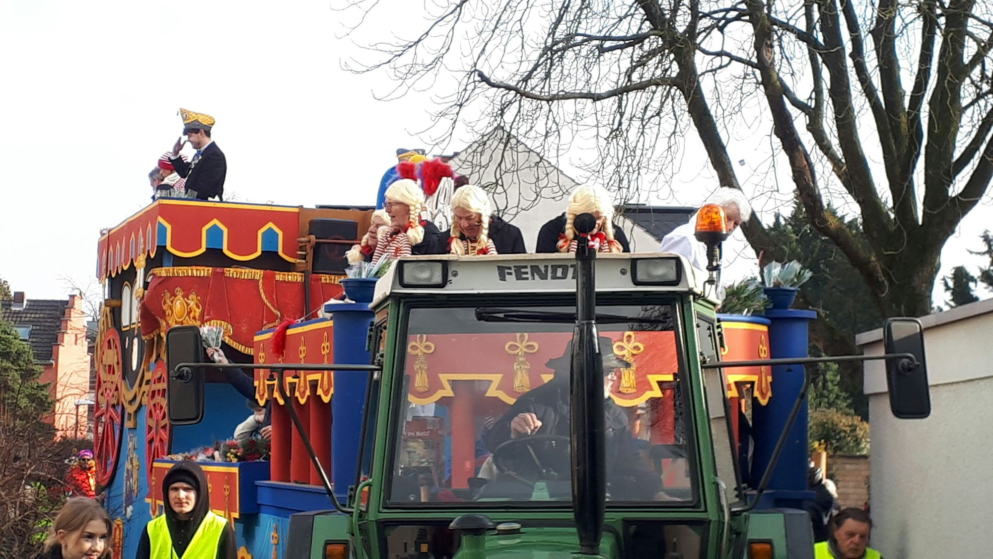 Ein Festwagen ist zu sehen, der von einem Traktor gezogen wird.