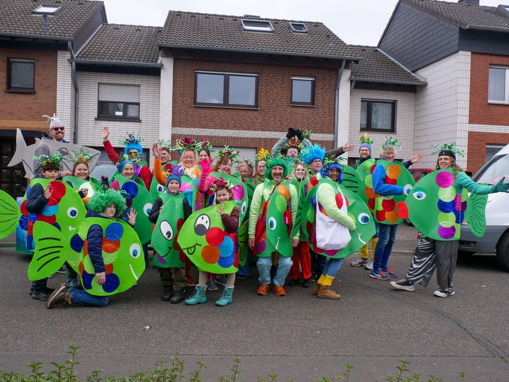 Auf dem Bild ist eine große Truppe zu sehen, die selbst gebastelte Fischkostüme trägt.
