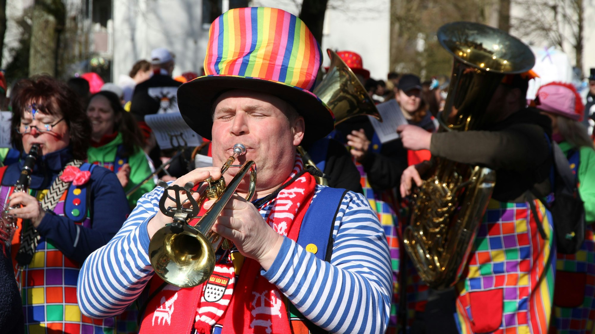 Ein verkleideter Mann spielt Trompete.