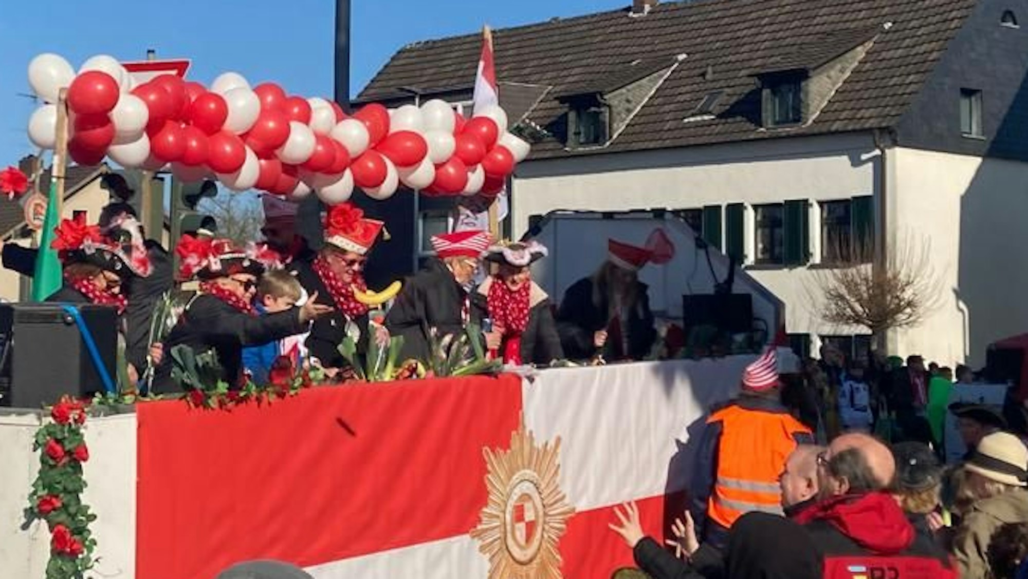 Eine Karnevalistin schmeißt eine Banane vom Wagen.