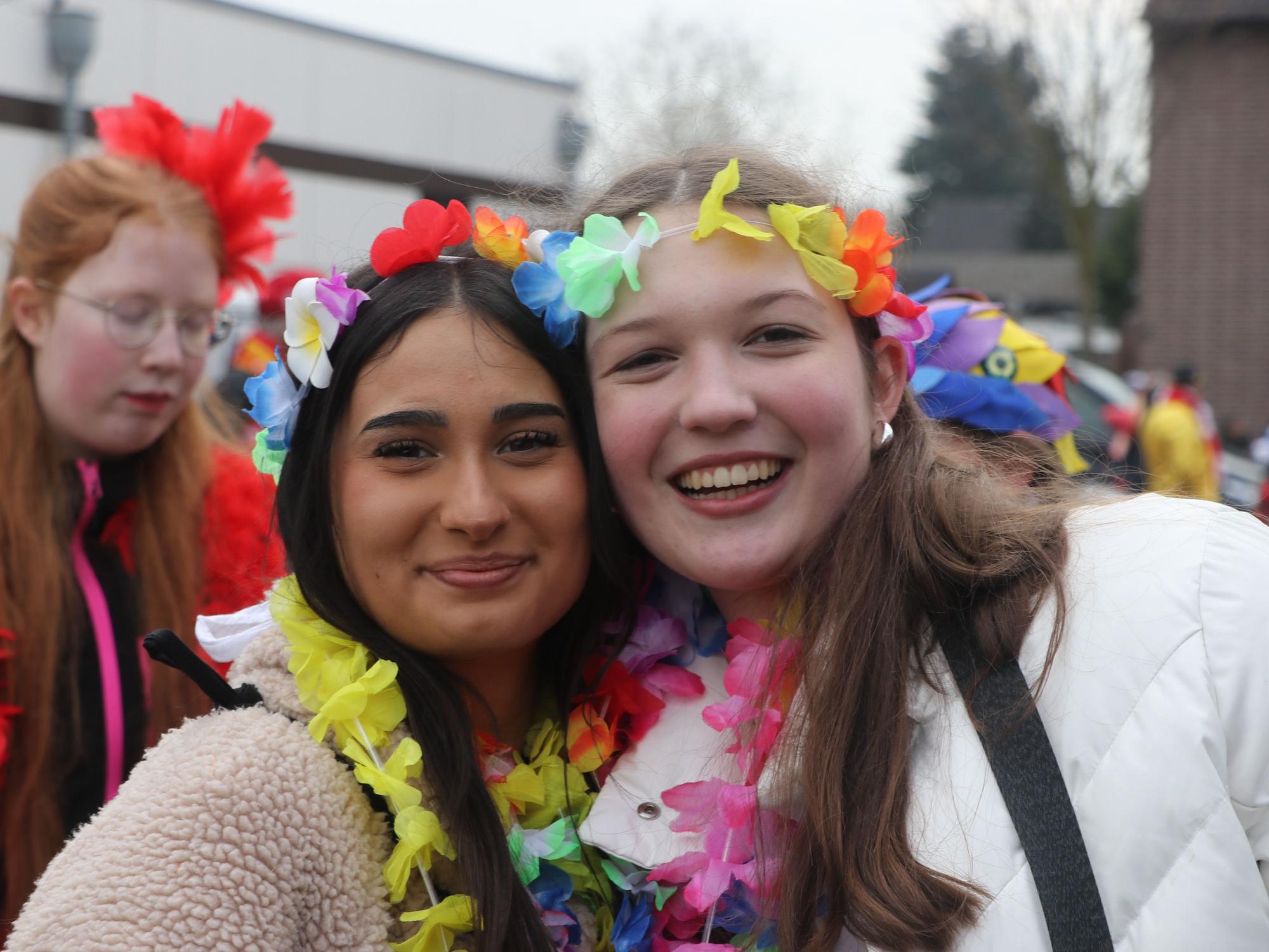 Auf dem Bild sind zwei junge Mädchen zu sehen, die Regenbogen-Girlanden tragen.