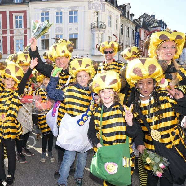 Kinder und Erwachsene in Bienenkostümen stehen auf der Straße im Gladbacher Zoch.