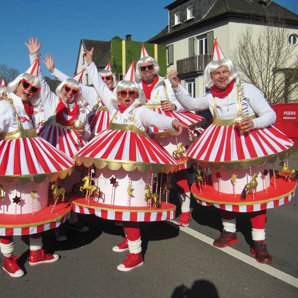Eine Gruppe in Karussell-Kostümen bei einem Karnevalszug.