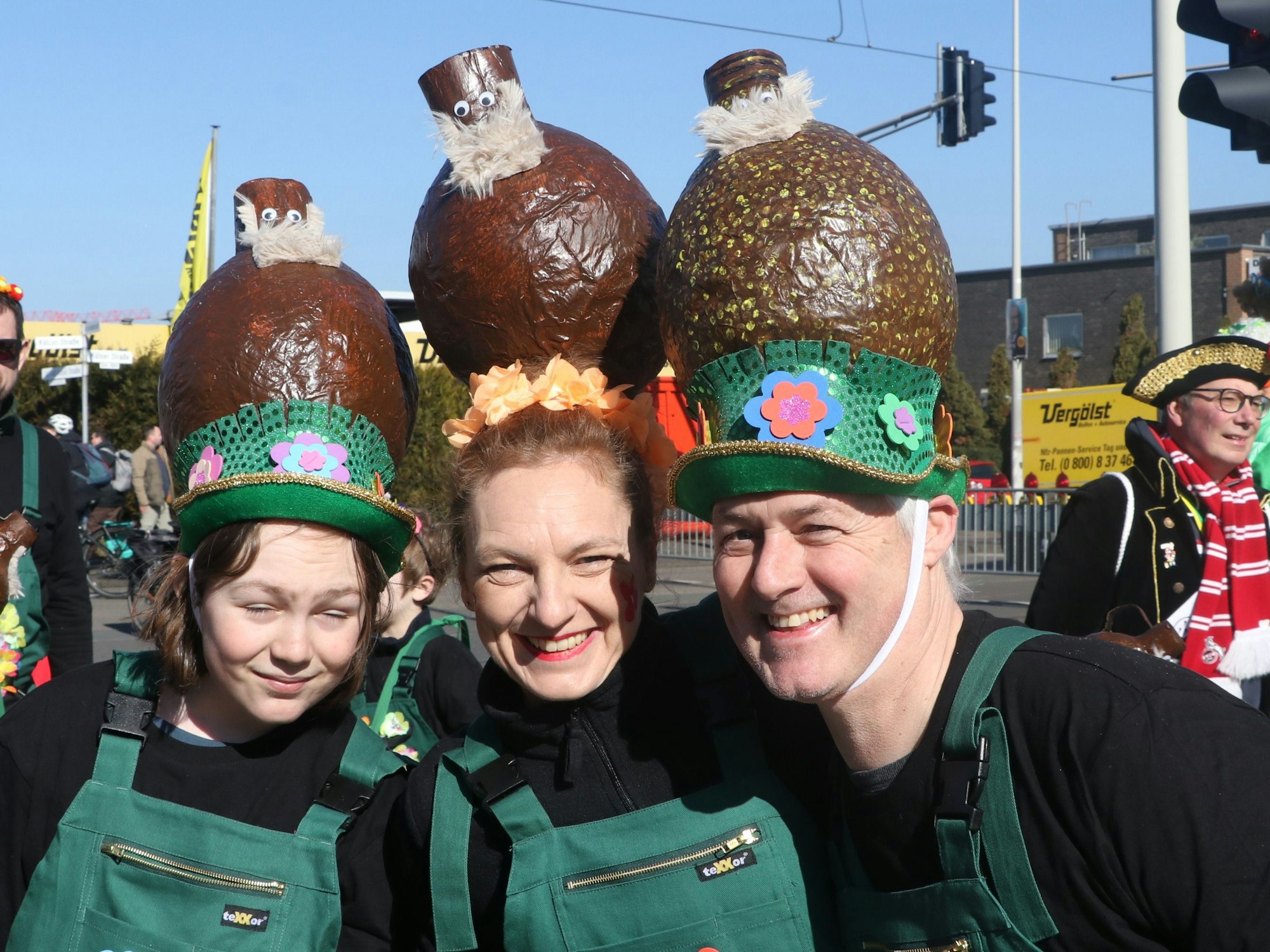 Auf dem Bild sind drei Personen zu sehen, die den Bartmannkrug als Hut tragen.