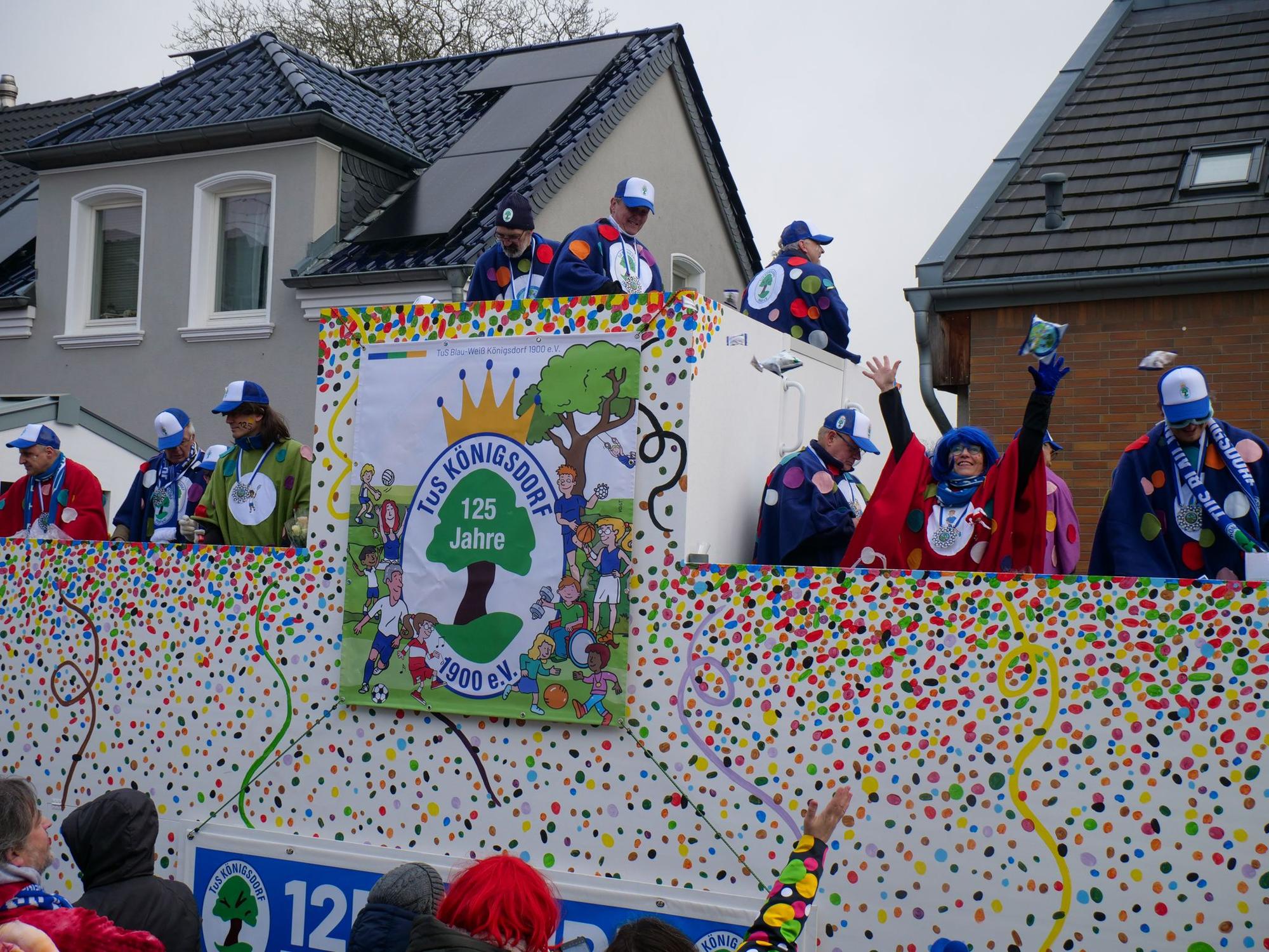 Auf dem Foto ist ein Karnevalswagen des TuS Königsdorf zu sehen, der mit bunten Punkten angemalt ist.