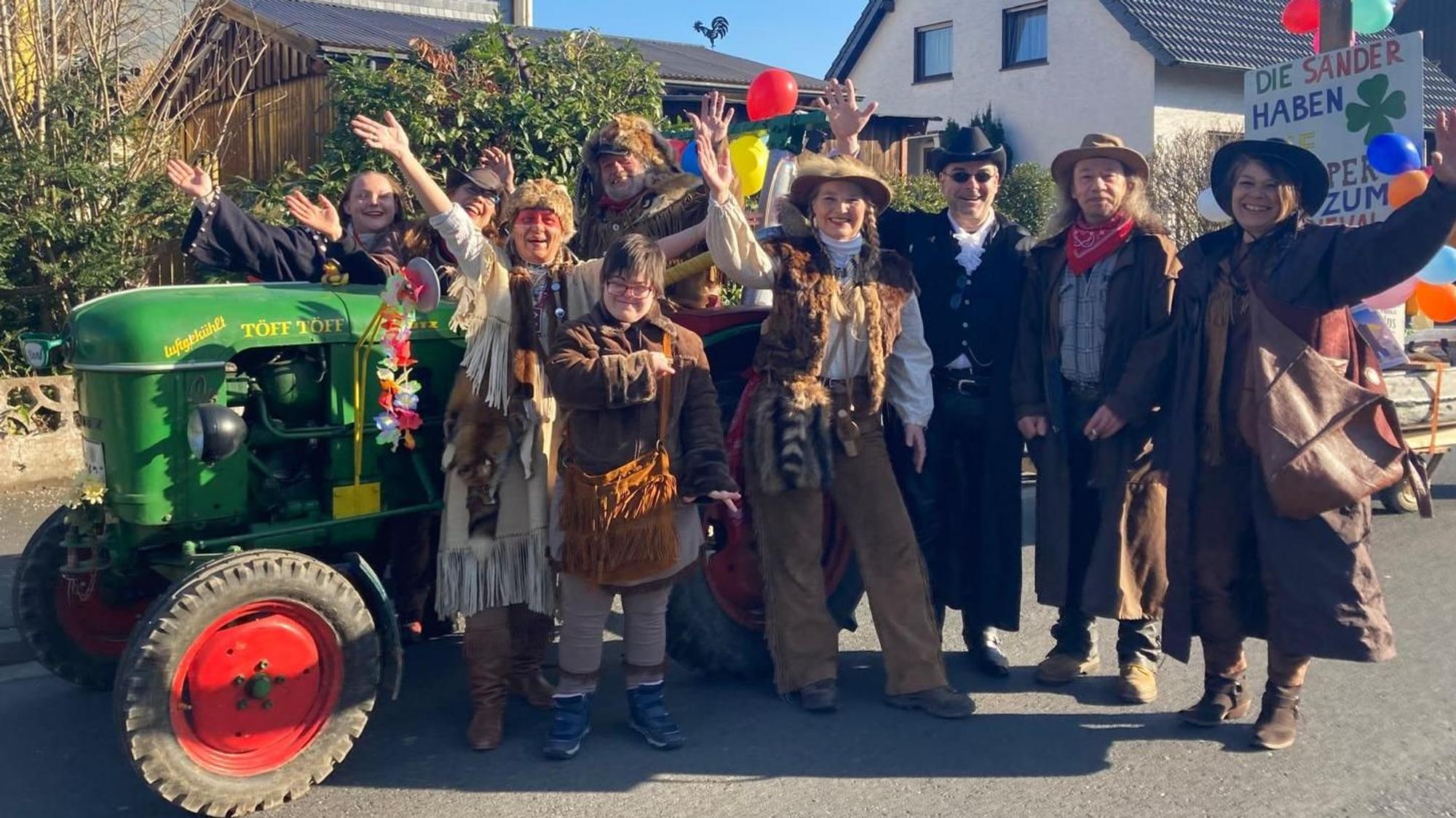 Eine als Indigene verkleidete Karnevalsgruppe winkt.