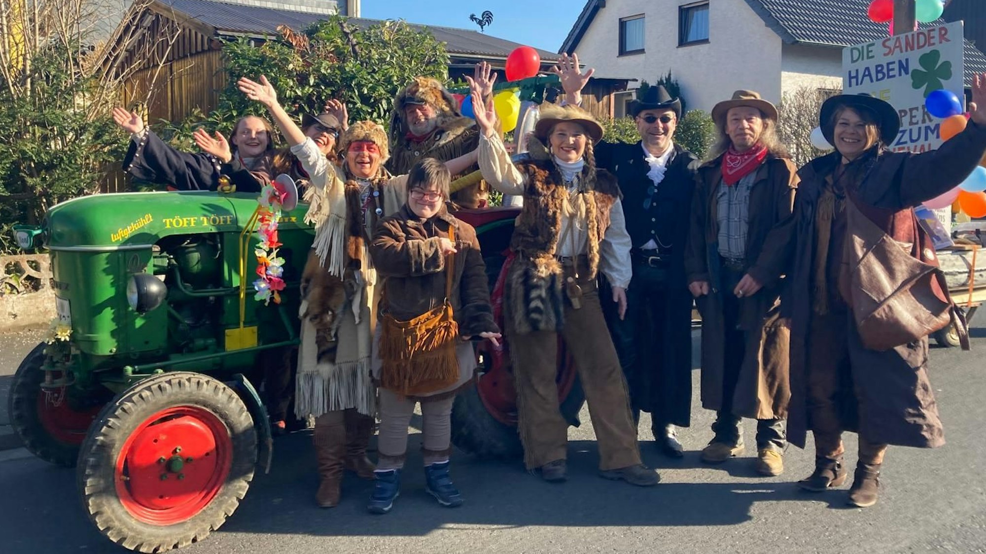 Eine als Indigene verkleidete Karnevalsgruppe winkt.