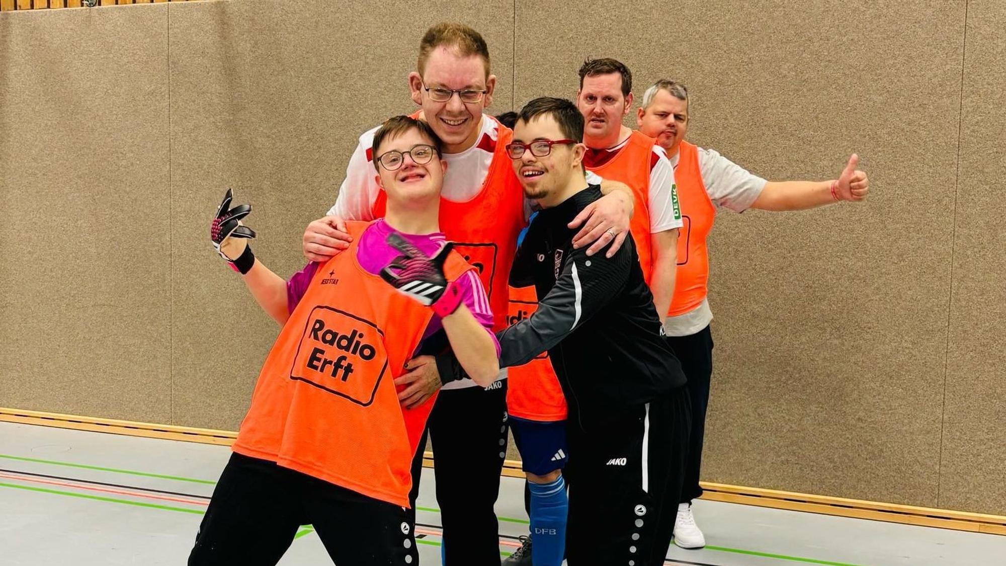 Das Bild zeigt fünf Fußballer in Trainingsbekleidung, denen der Spaß am Sport abzulesen ist.