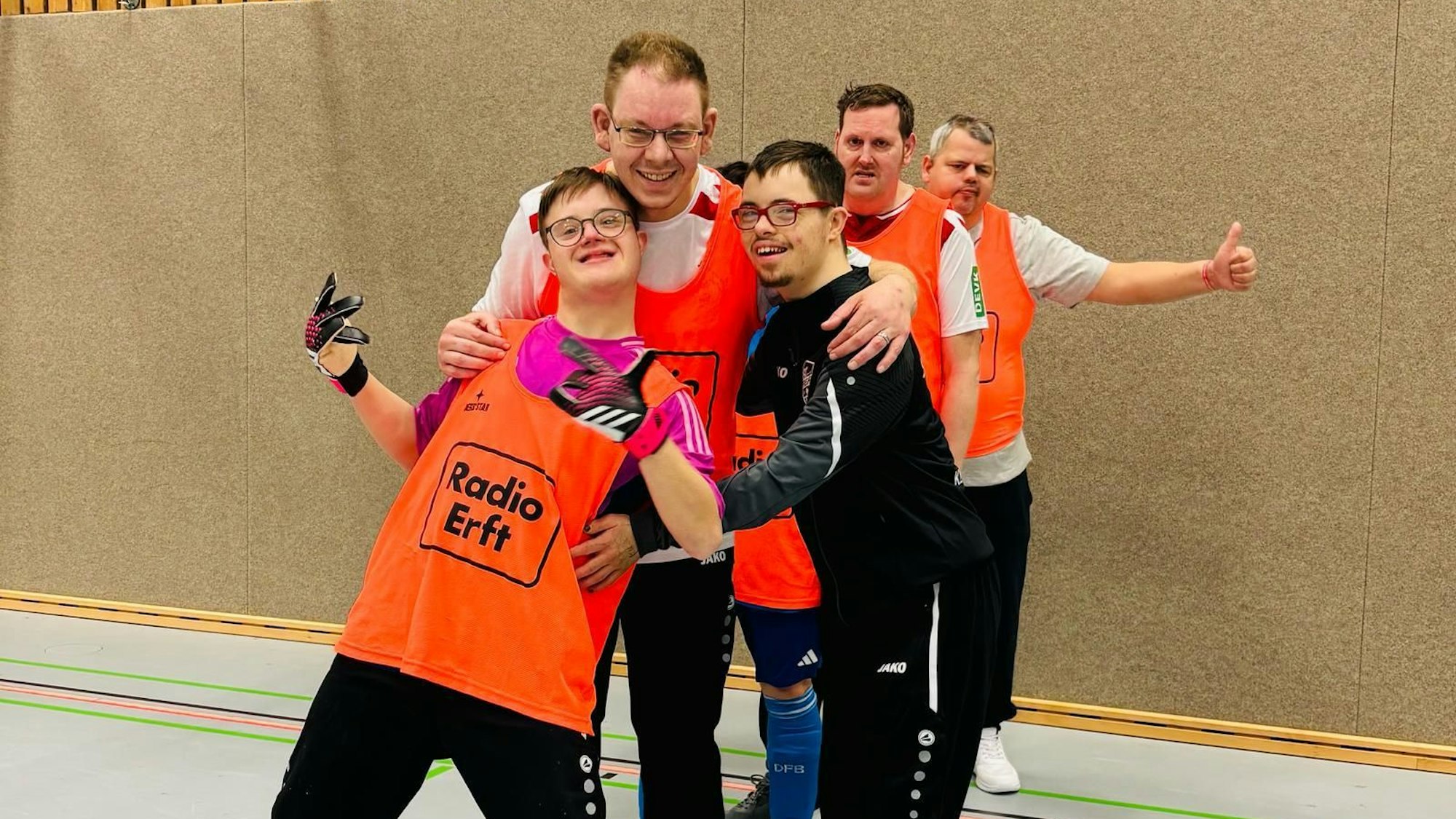 Das Bild zeigt fünf Fußballer in Trainingsbekleidung, denen der Spaß am Sport abzulesen ist.