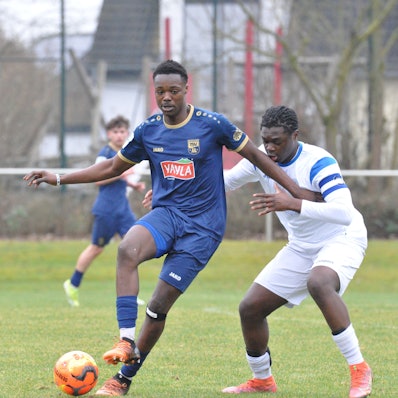 Das Foto zeigt einen Fußballer im blauen Trikot, der den Ball vor seinem Königsdorfer Gegenspieler abschirmt.