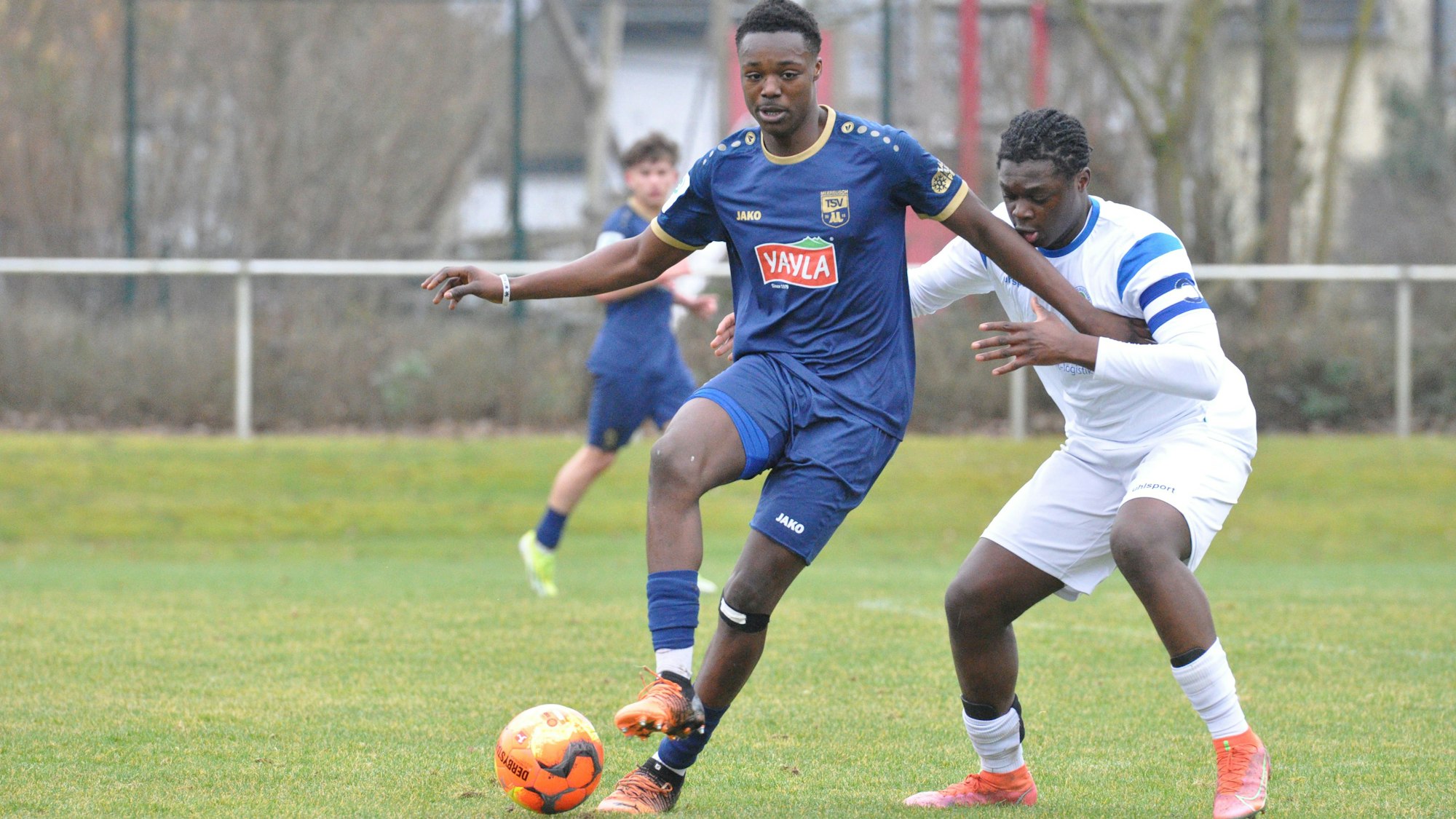 Das Foto zeigt einen Fußballer im blauen Trikot, der den Ball vor seinem Königsdorfer Gegenspieler abschirmt.