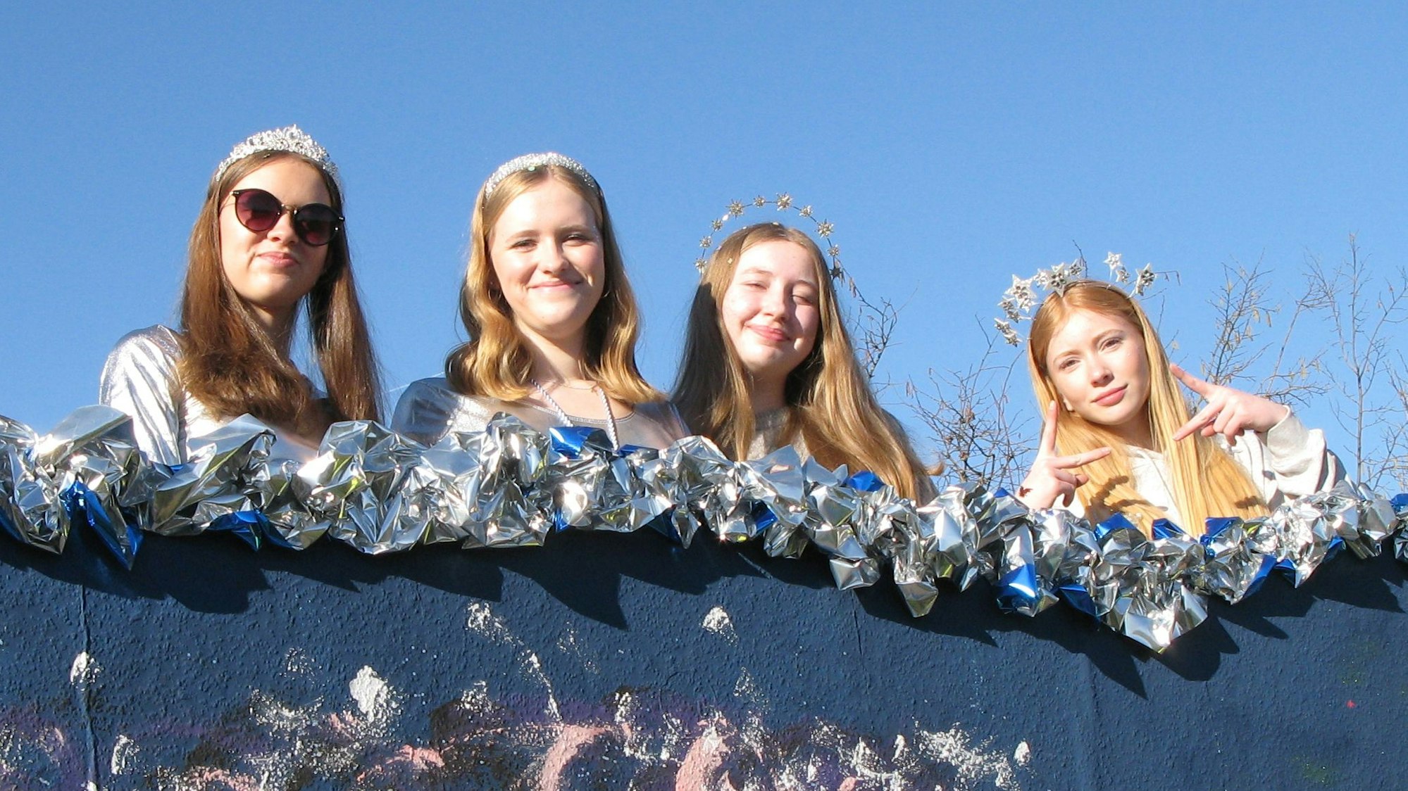 Vier junge Frauen mit Sternen-Diademen auf dem Kopf.