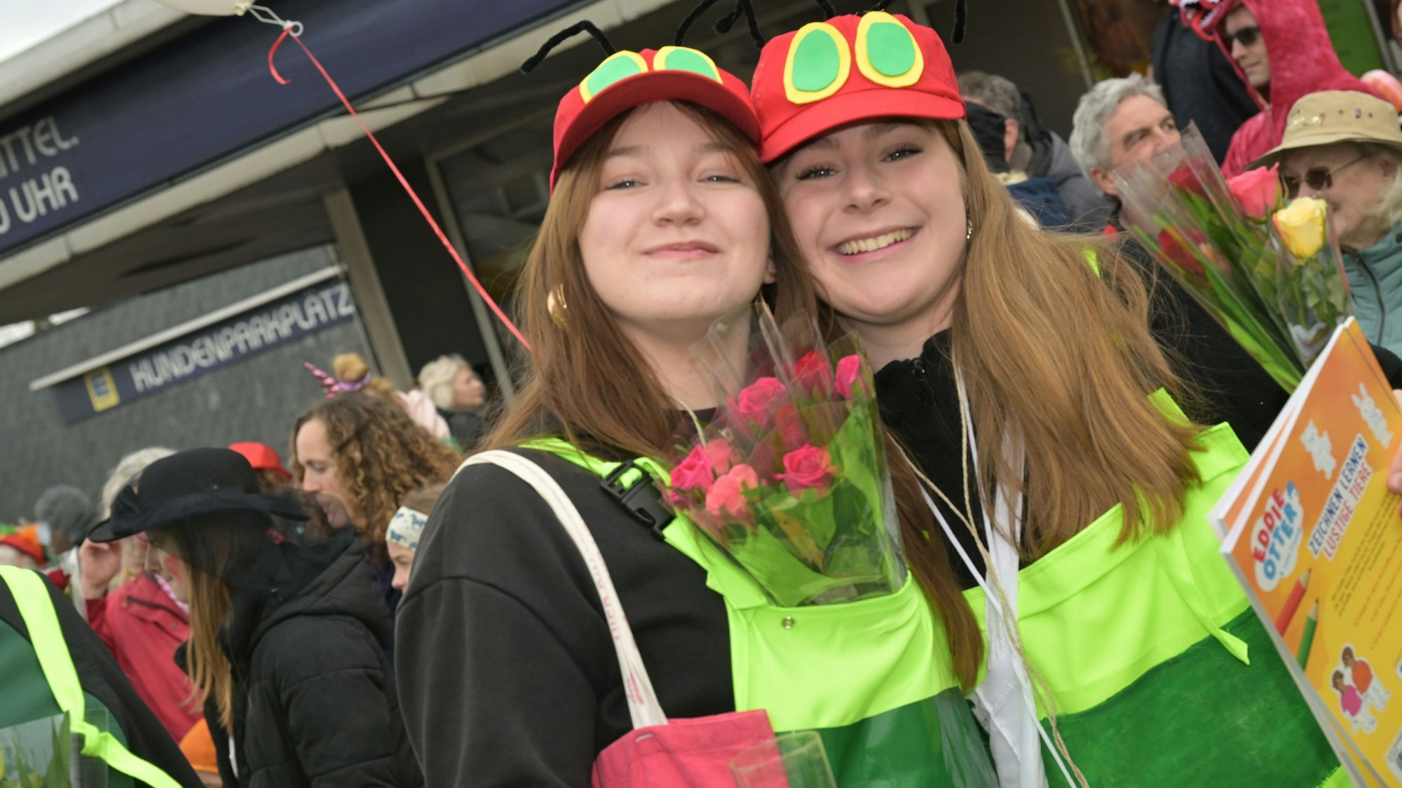 Zwei junge Frauen in einem Raupe-Nimmersatt-Kostüm eißen die Hände in die Höhe.