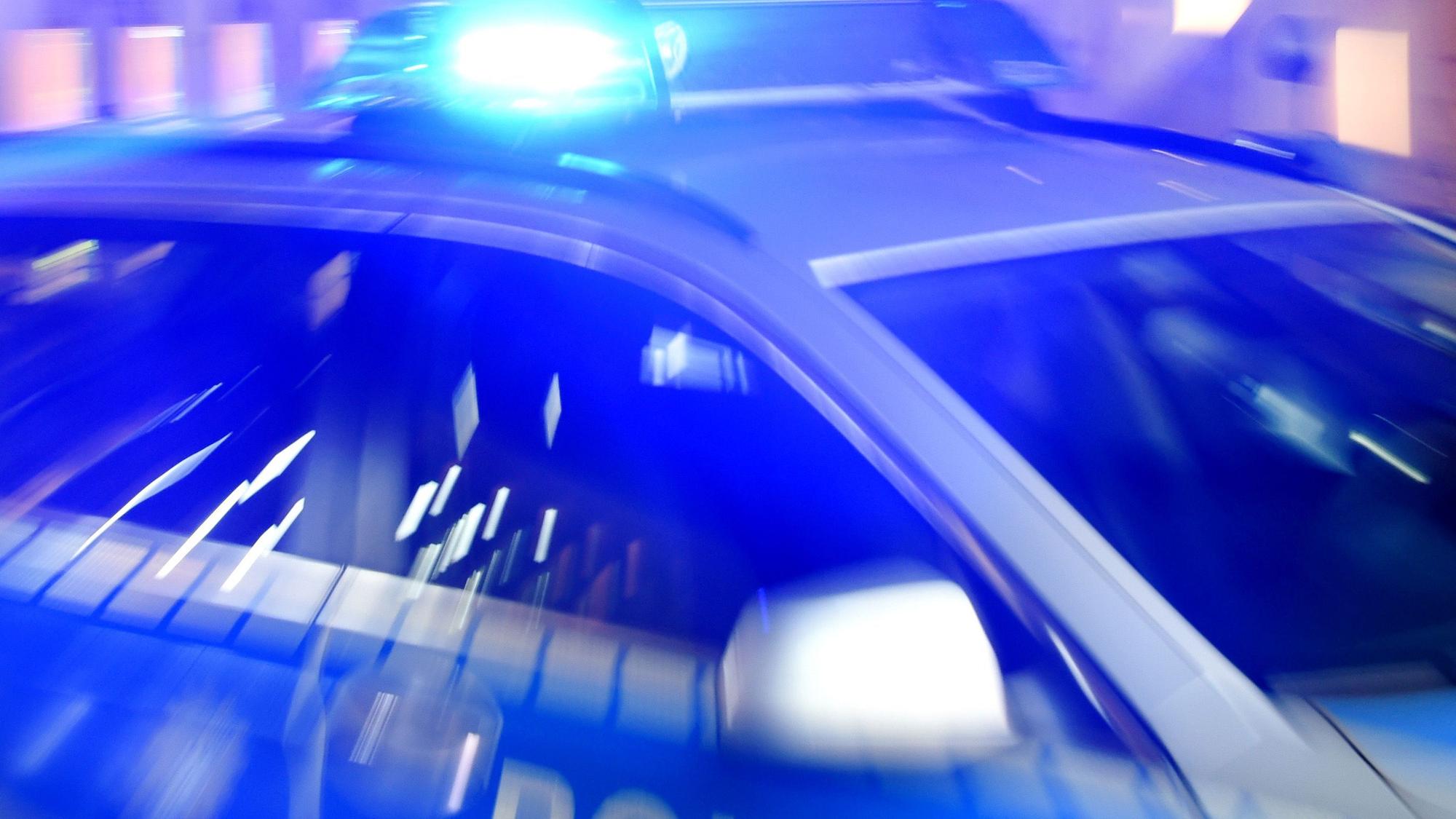 ARCHIV - 06.08.2015, Schleswig-Holstein, Flensburg: Ein Streifenwagen der Polizei steht mit eingeschaltetem Blaulicht auf der Straße.
