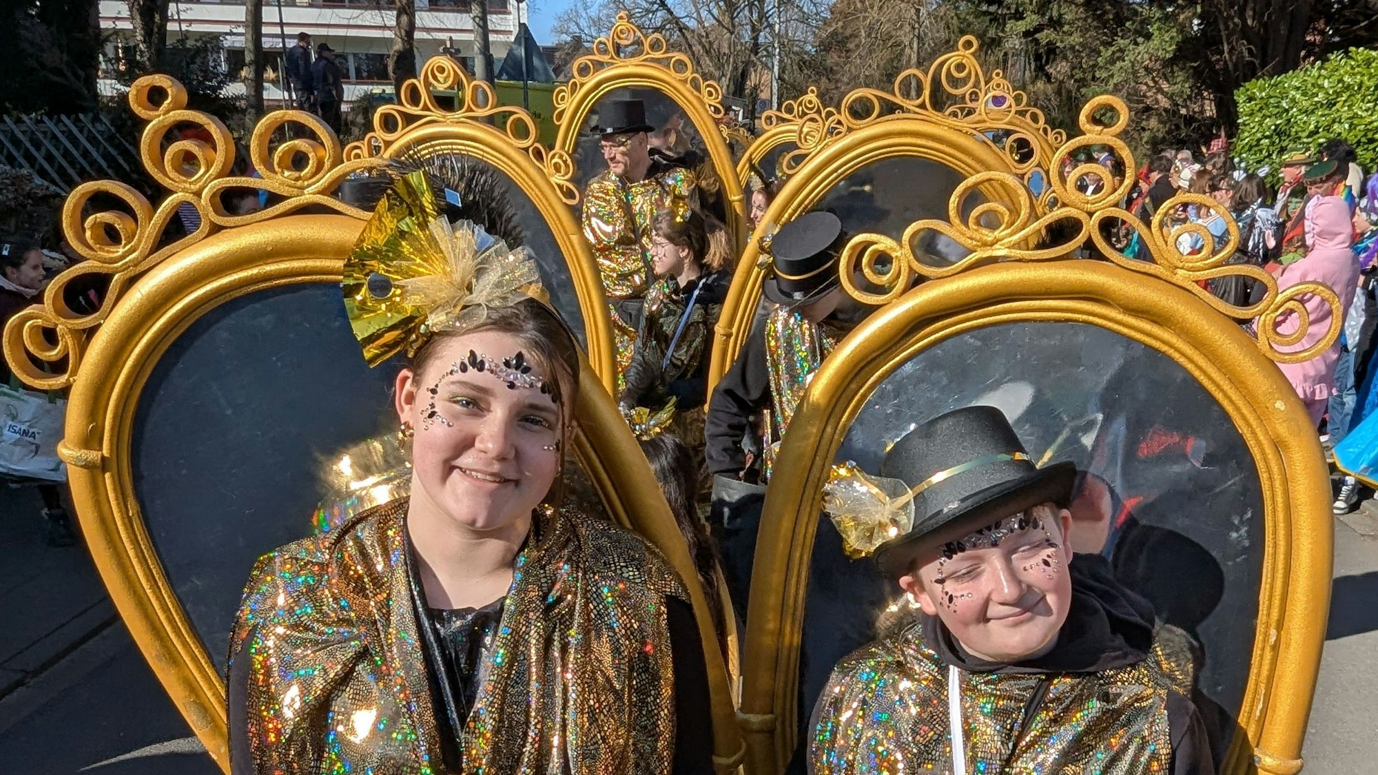Das Foto zeigt eine Fußgruppe, die große Spiegel auf dem Rücken trägt.