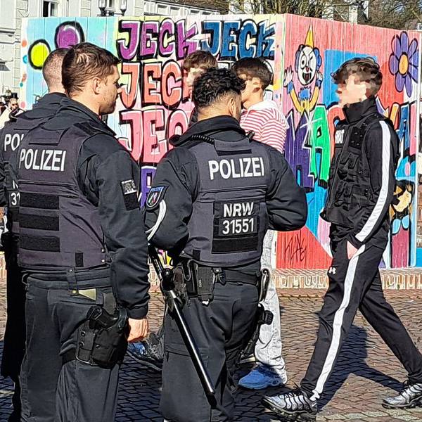 Bereitschaftspolizisten stehen am Konrad-adenauer-Platz in Bergisch Gladbach unweit der Karnevalsabdeckung des Papierschöpfbrunnens-.
