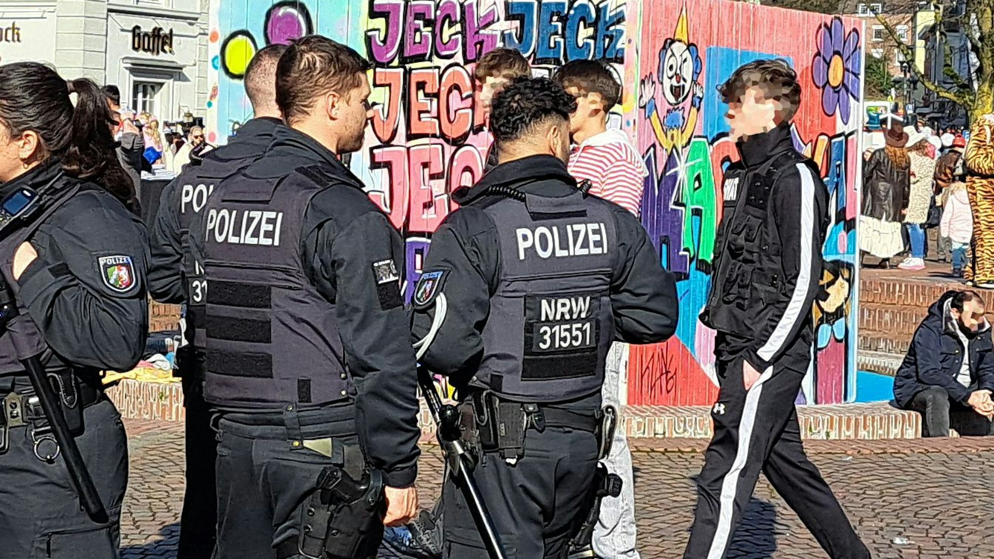 Bereitschaftspolizisten stehen am Konrad-adenauer-Platz in Bergisch Gladbach unweit der Karnevalsabdeckung des Papierschöpfbrunnens-.