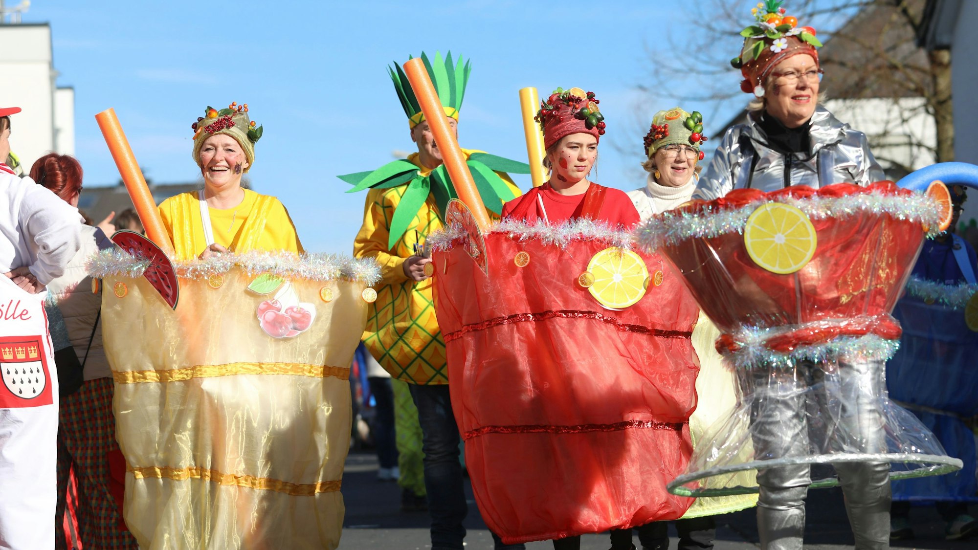 Mehrere Karnevalisten in gelben und roten Kostümen, die ein Cocktailglas darstellen.