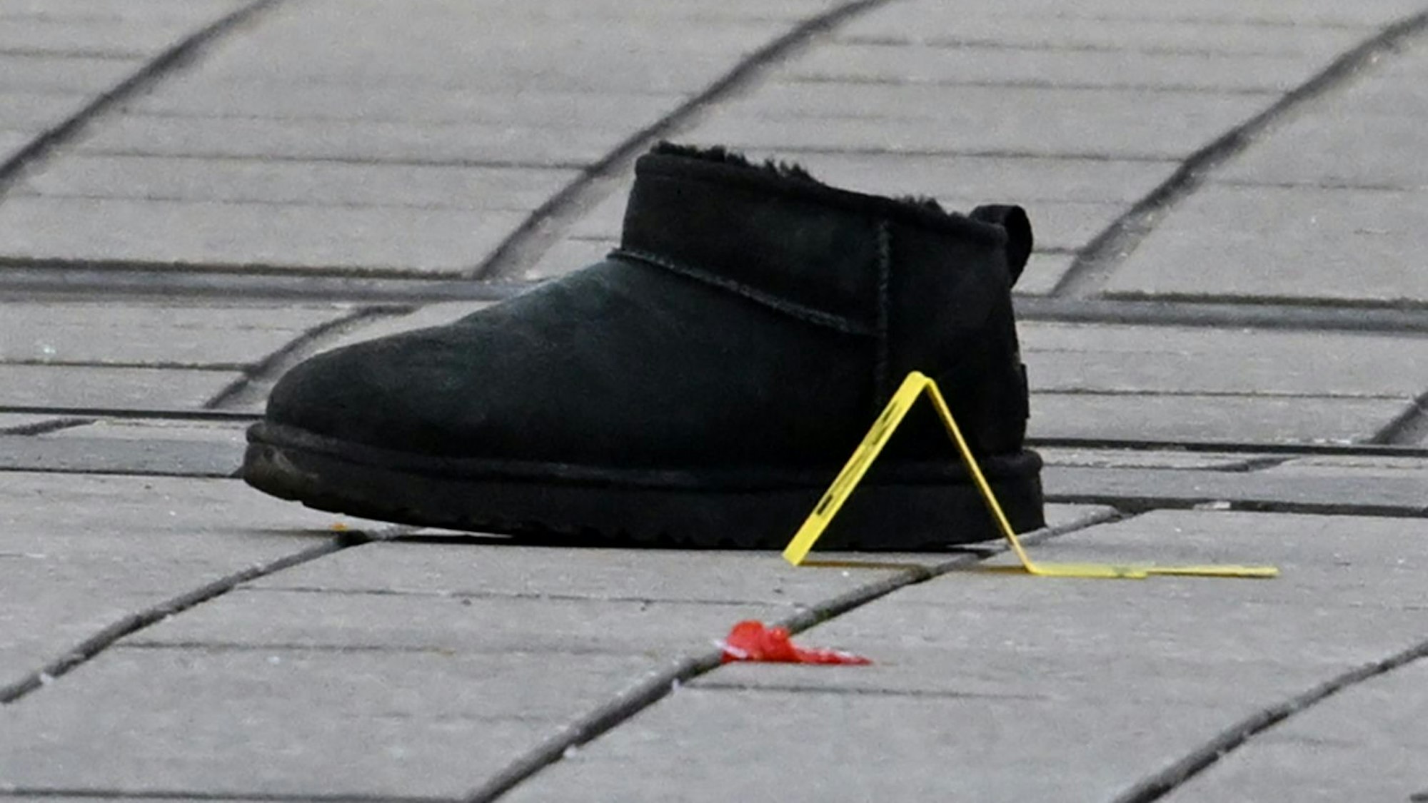 Ein Schuh mit einer Markierung der Polizei ist in der Mannheimer Innenstadt zu sehen.