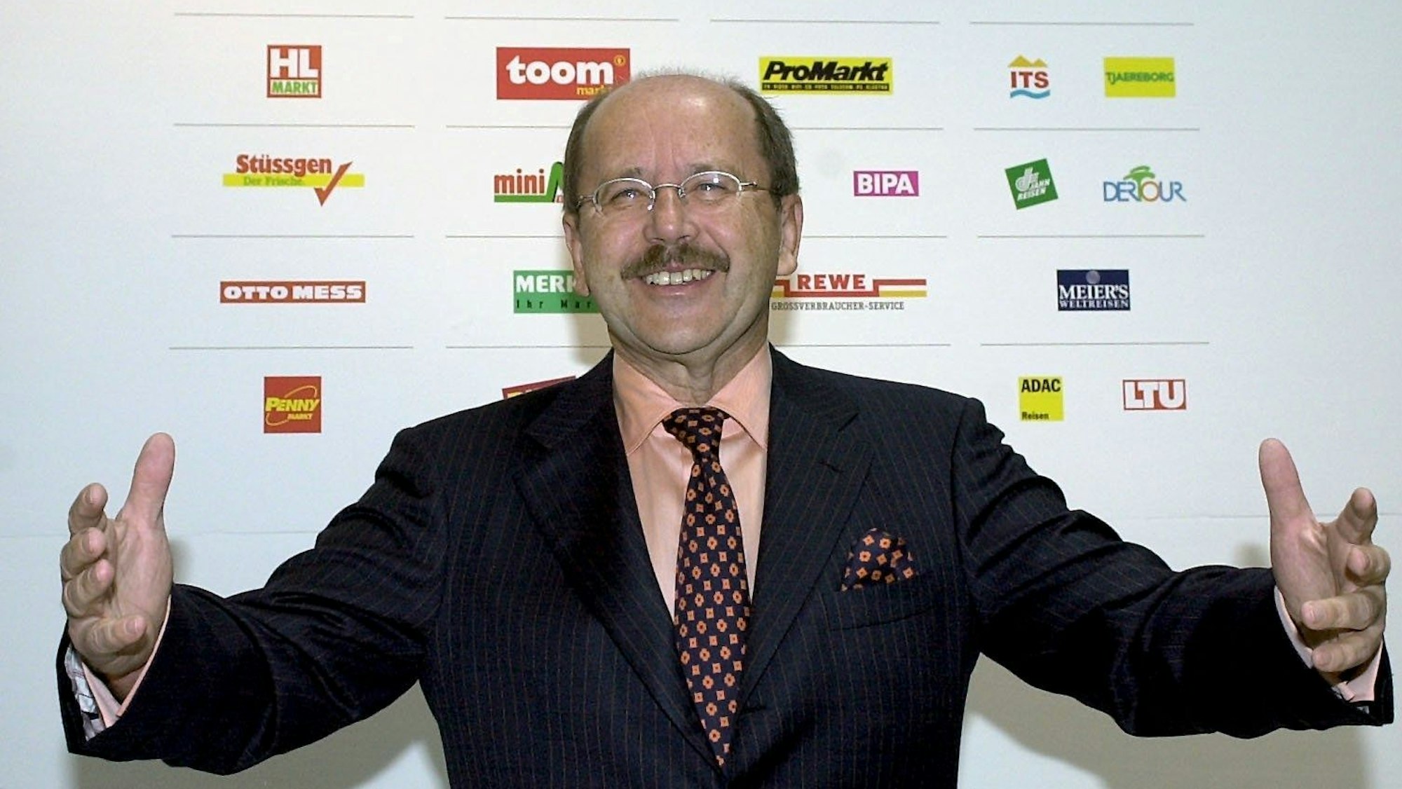 Hans Reischl, Vorstandsvorsitzender der REWE-Zentral AG und der REWE-Zentralfinanz eG steht am Mittwoch (04.03.2003) vor einem Display mit den Markenzeichen der zur Zentralorganisation gehörenden Firmen, bevor er bei der Jahrespressekonferenz in Köln die Zahlen für das vergangene Jahr bekannt gibt. Fotograf: Roland Scheidemann dpa/lnw