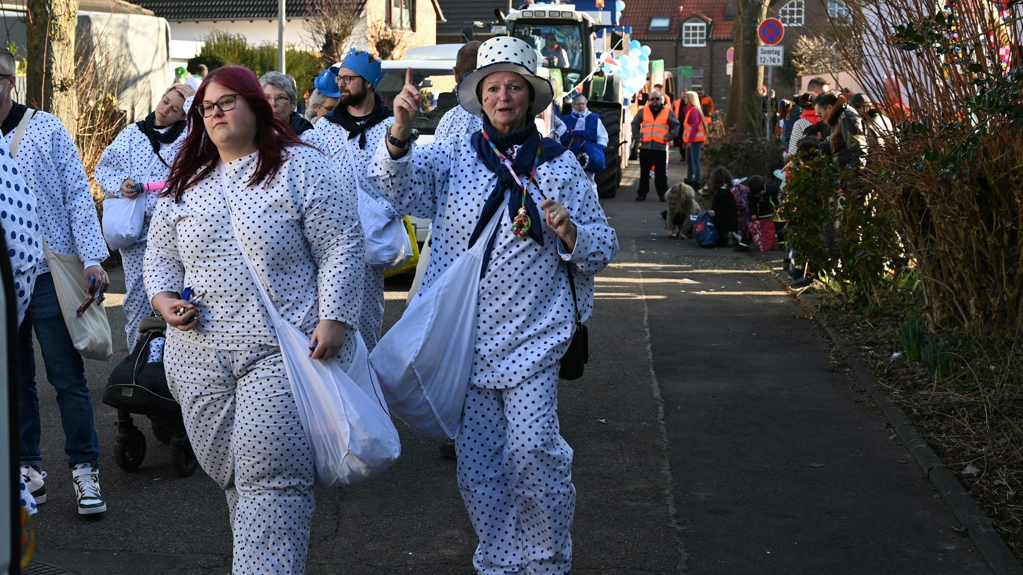 Auf dem Bild sind Frauen in gepunkteten Kostümen zu sehen.